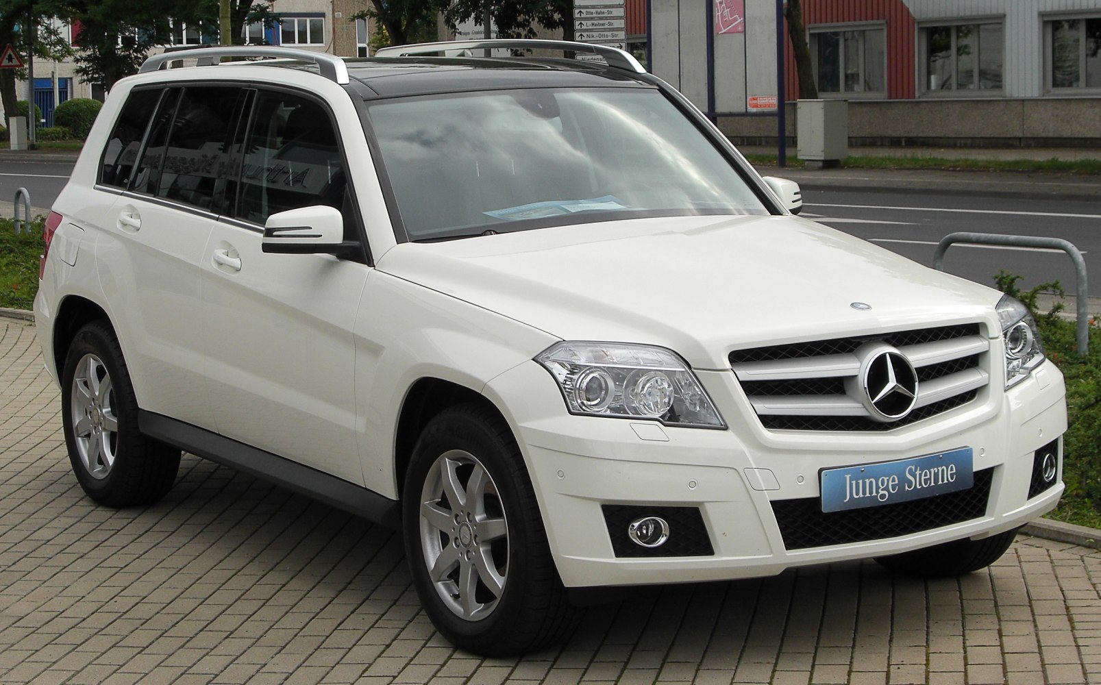 White SUV with large grille, angular headlights, and roof rails