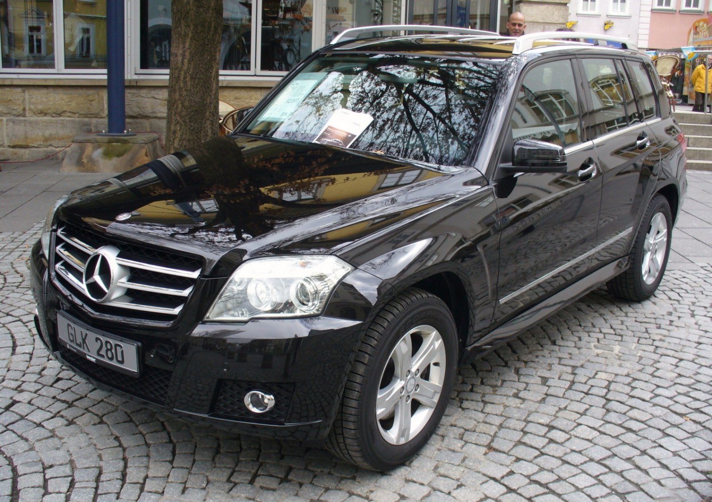 Black luxury SUV with chrome grille, alloy wheels, and roof rails