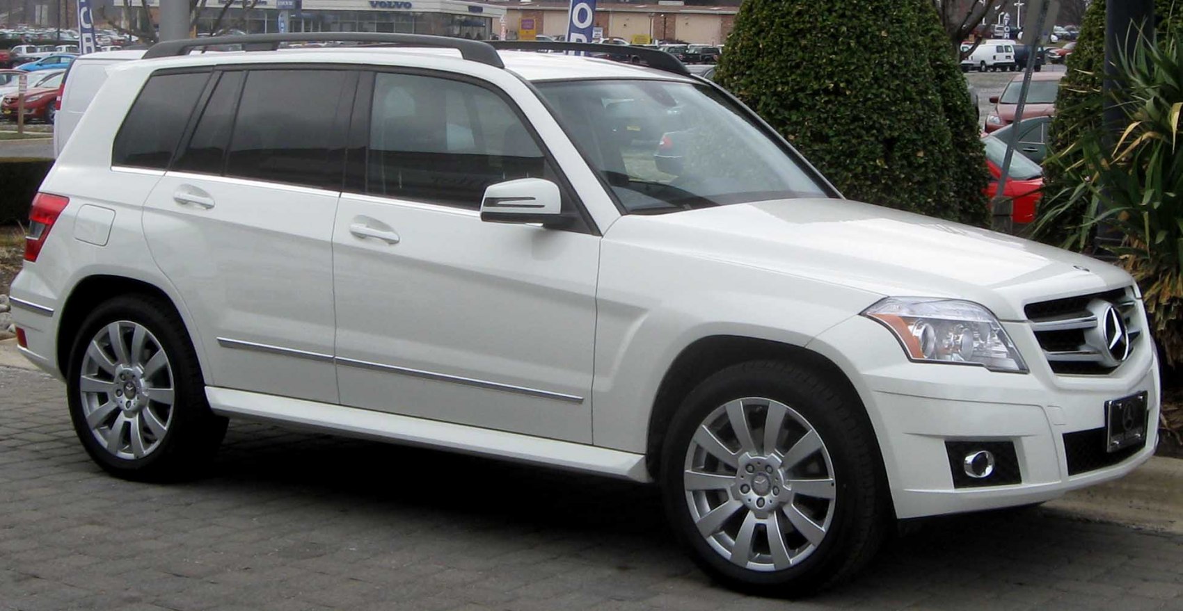 Front side view of white luxury SUV with grille and alloy wheels
