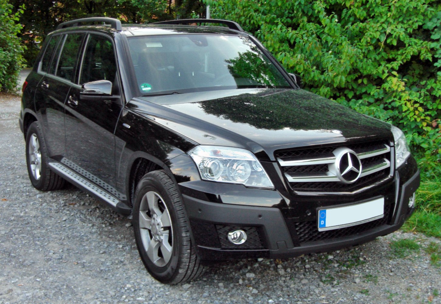 Front and side profile of a black SUV with grille and headlights