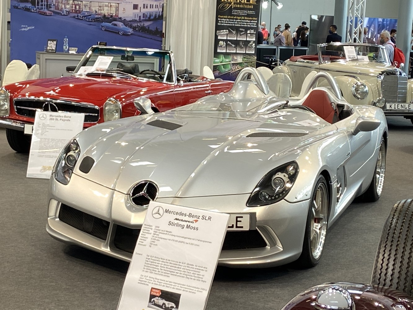 Silver twin-cockpit open-top roadster with aerodynamic design.
