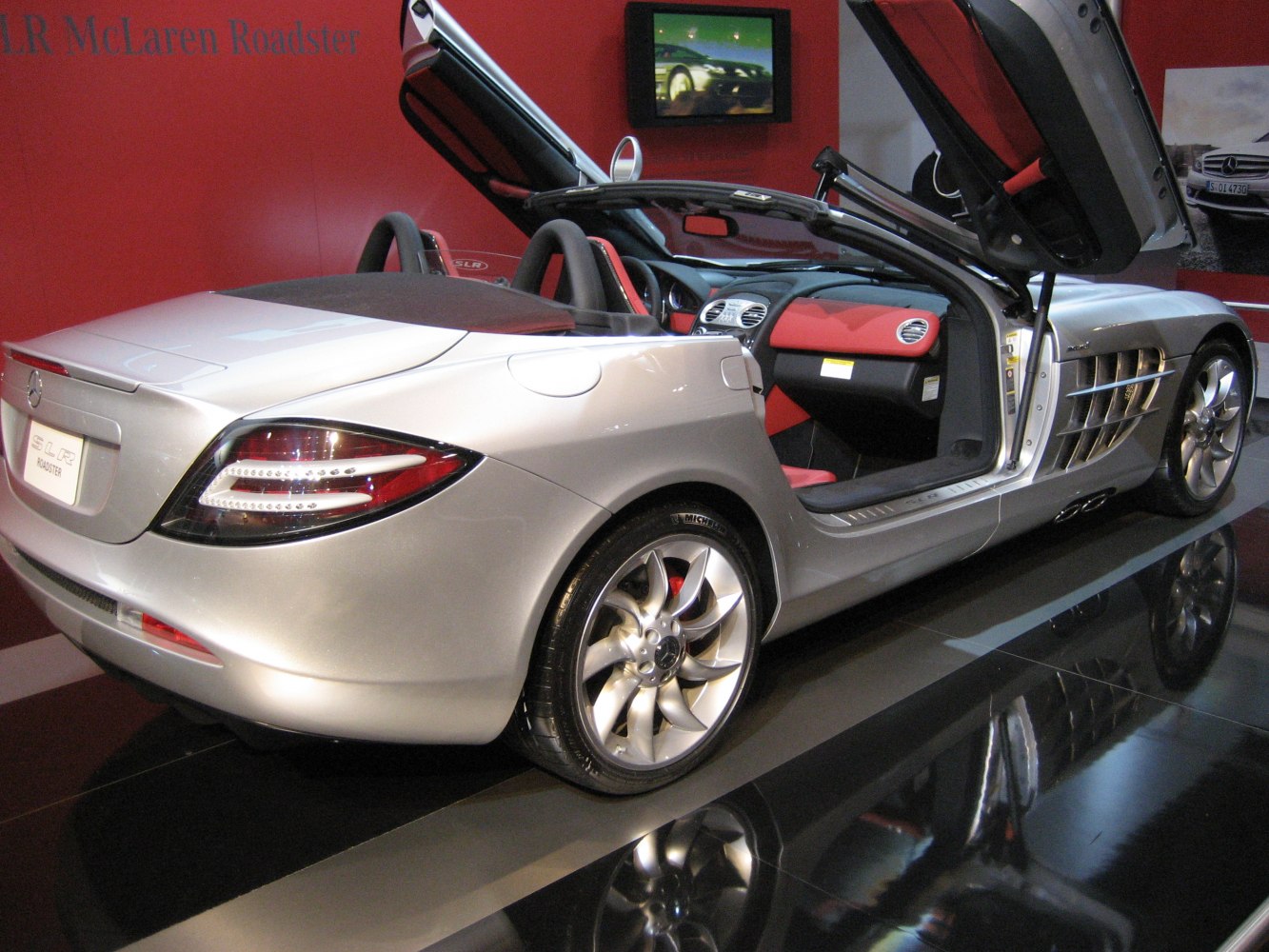Butterfly doors open, sleek rear, sporty wheels, red-black interior