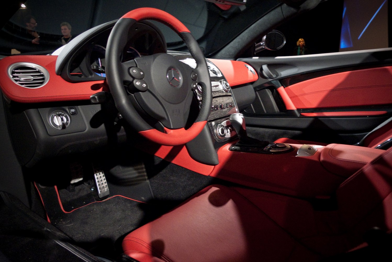 Red and black luxury car interior with carbon fiber dashboard and advanced control layout
