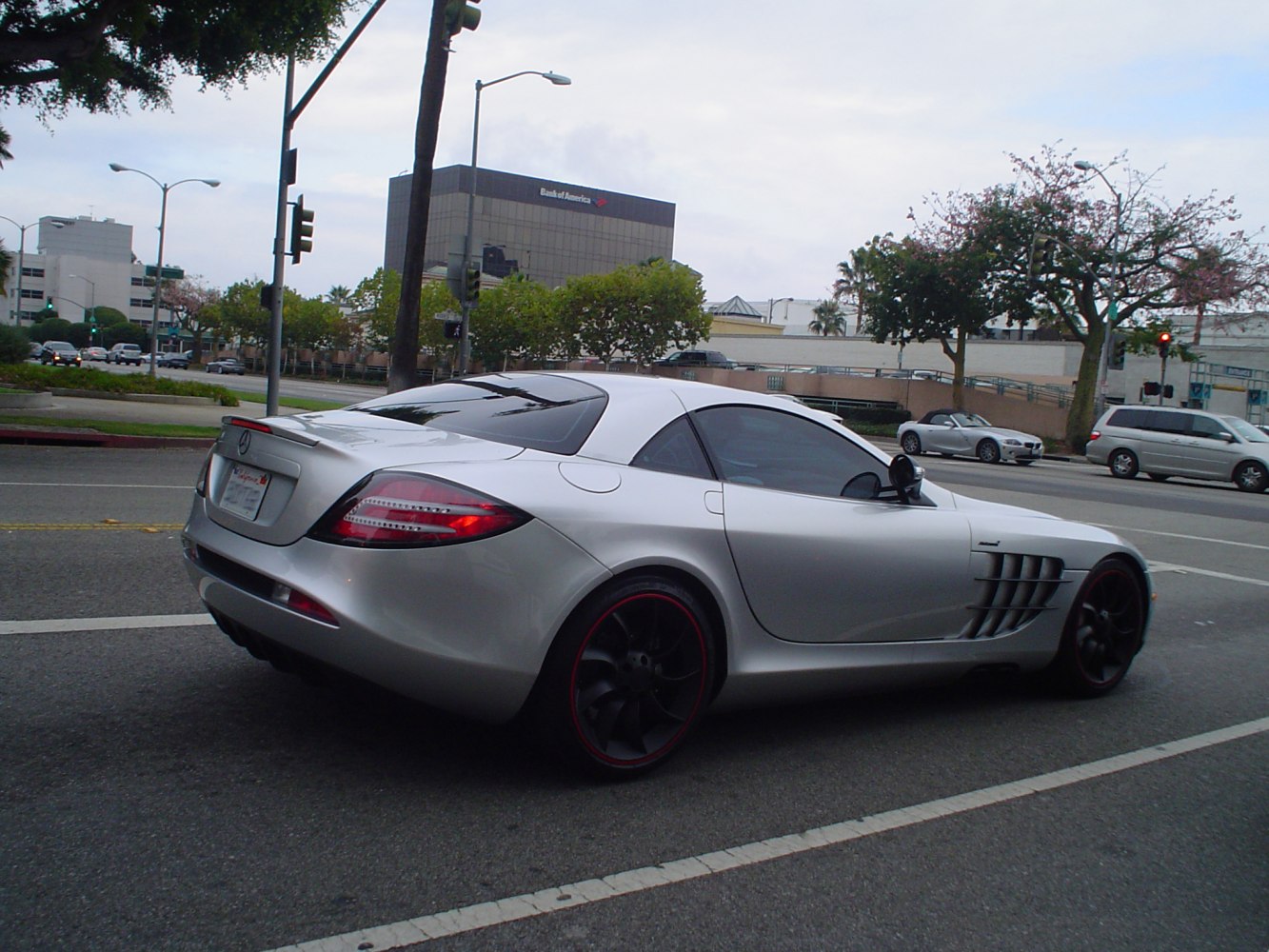 Rear view of a silver sports coupe with black wheels and side air vents.
