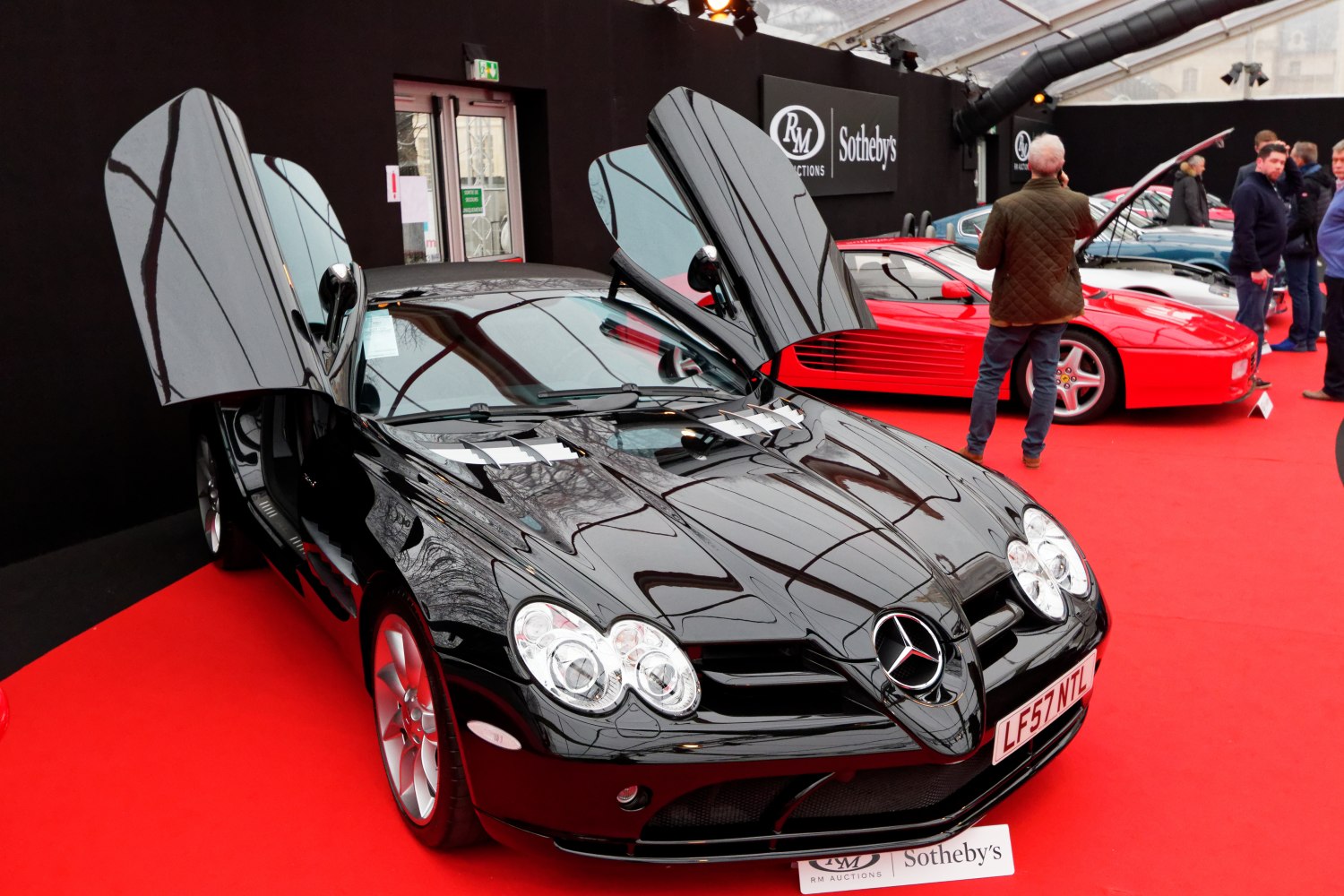 Black sports roadster with iconic butterfly doors open.