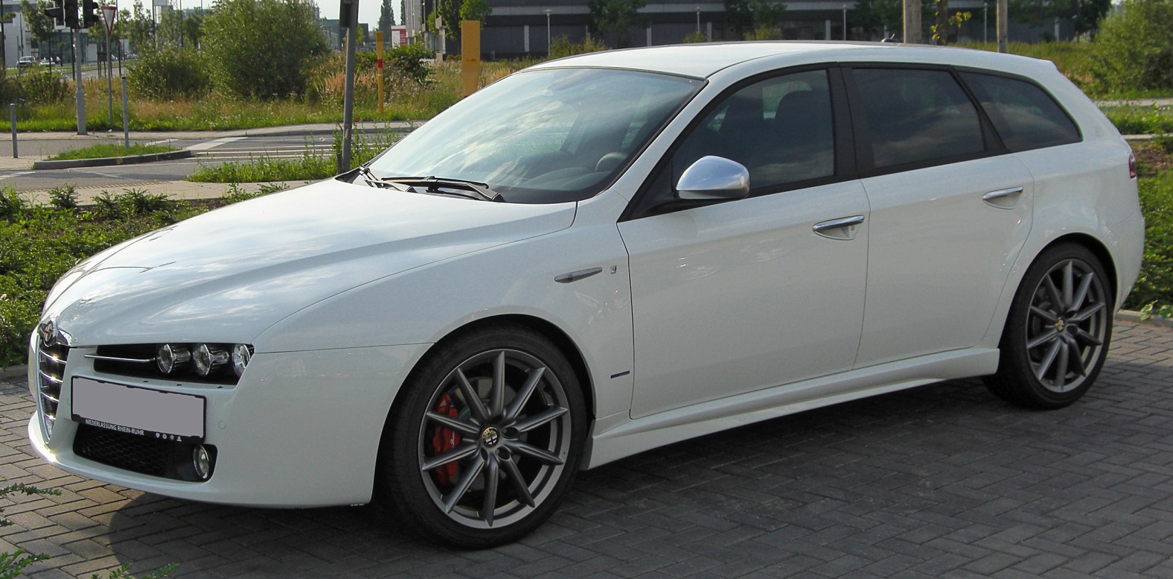 White sportwagon with multi-spoke alloy wheels and red brake calipers.
