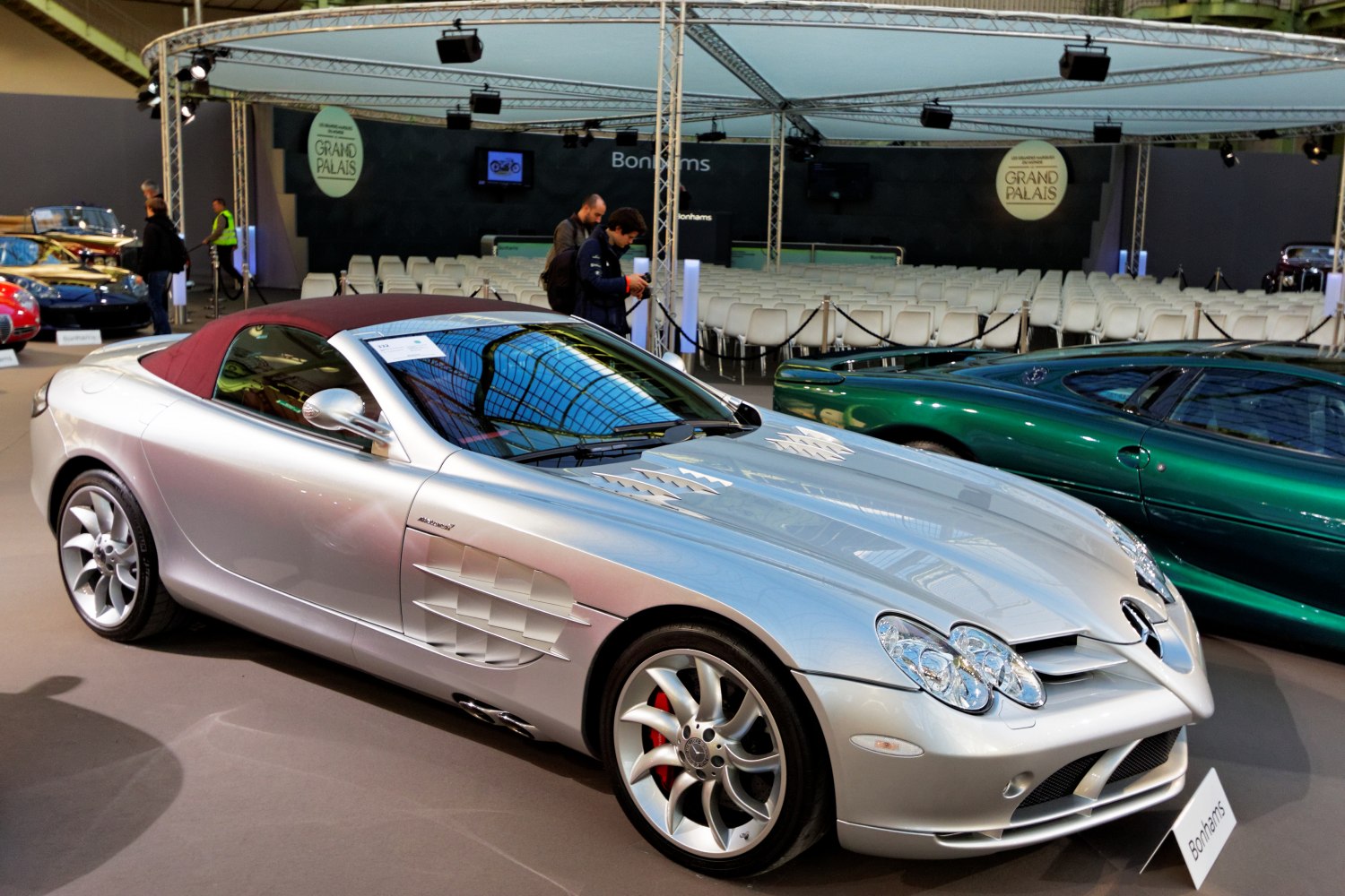 Silver roadster with vented hood, alloy wheels, and soft-top roof