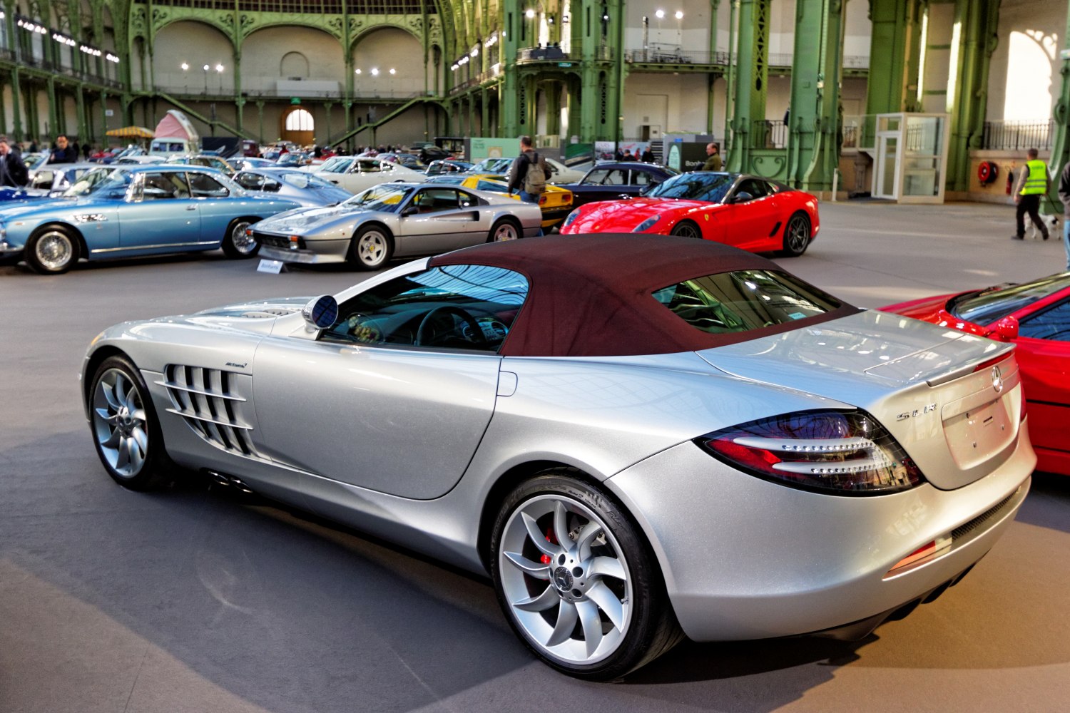 Silver convertible roadster with maroon soft top and side air vents