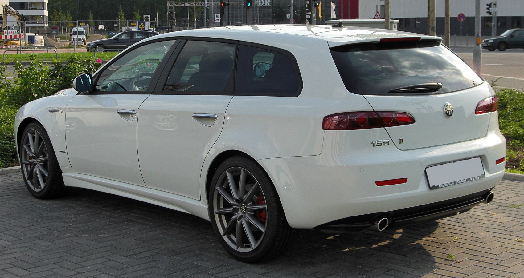 Rear side view of a white station wagon with alloy wheels and dual exhausts