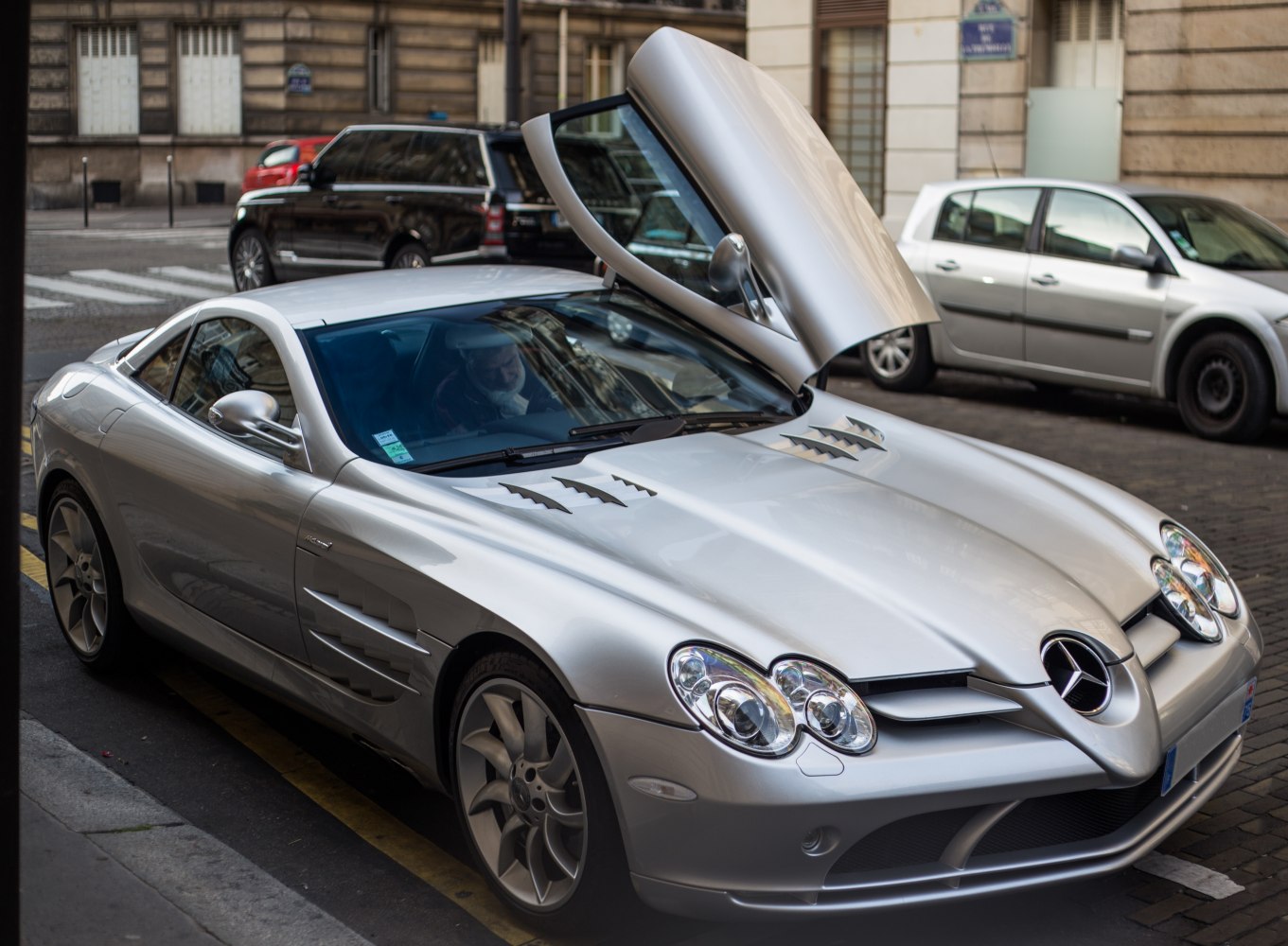 Silver sports coupe with butterfly door and ventilation grills