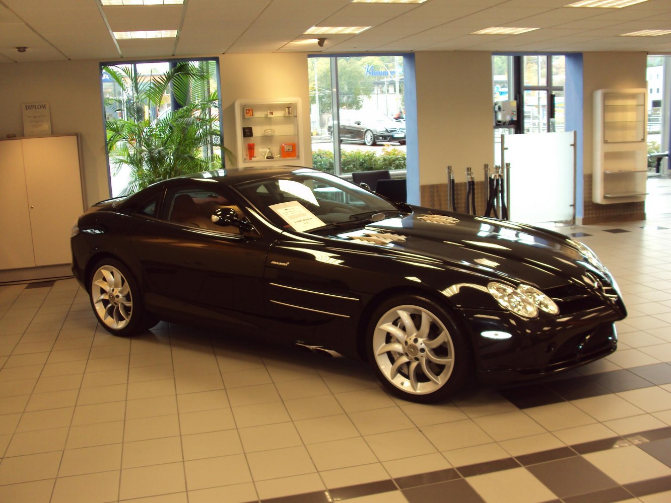 Black sleek coupe with aerodynamic design and distinctive wheels in showroom.