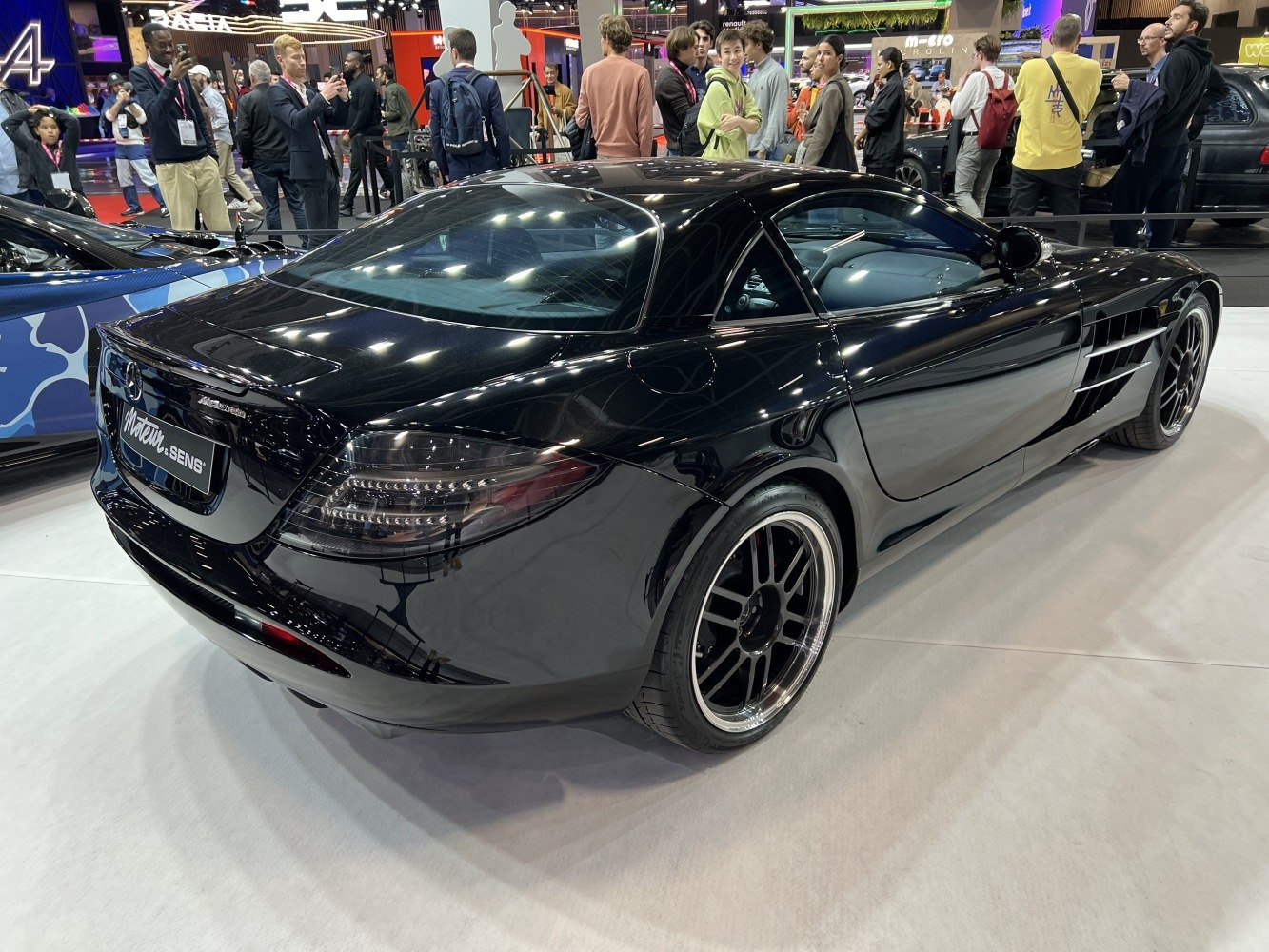 Rear and side view of black sports coupe with custom multi-spoke rims