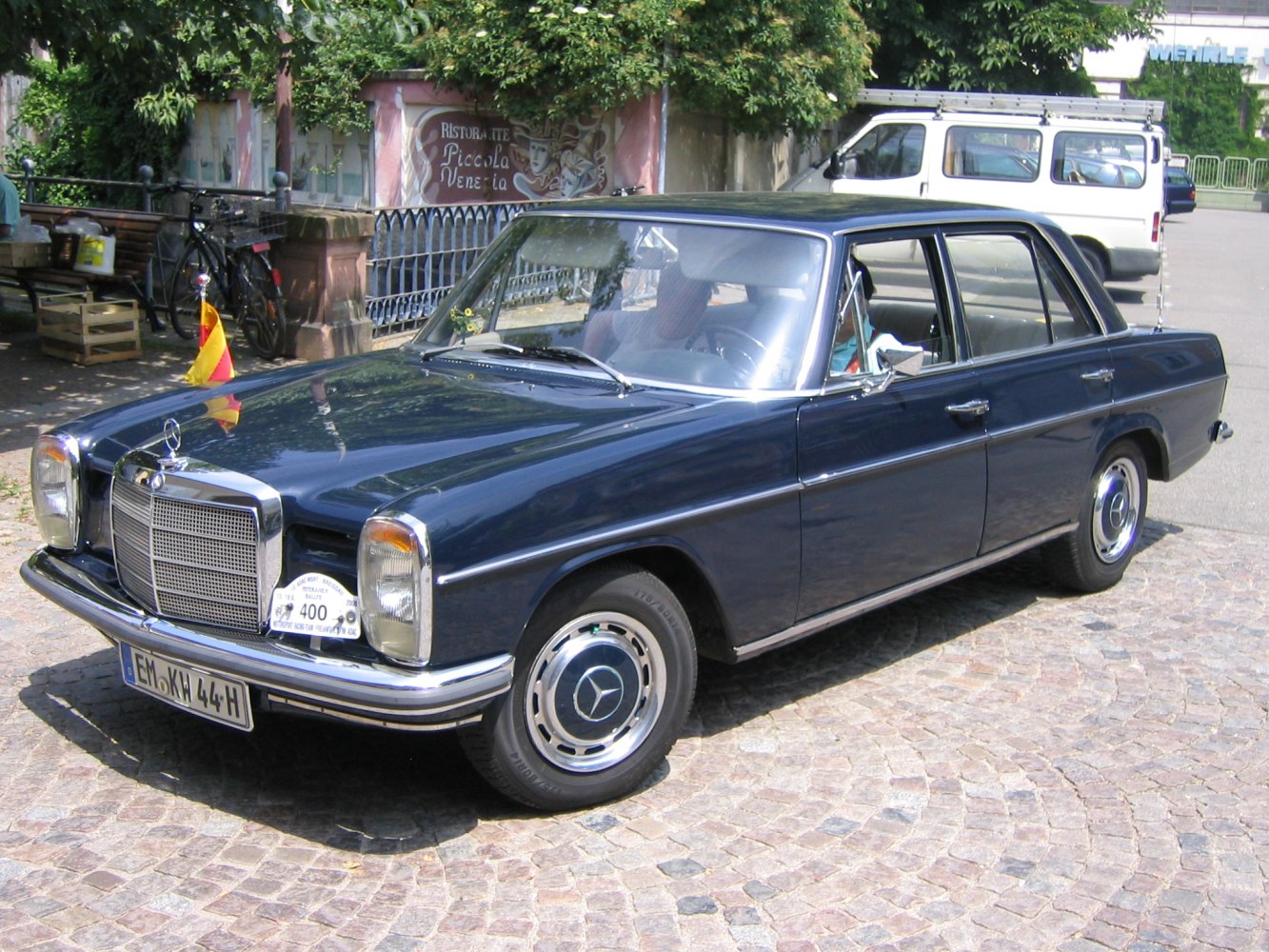 Vintage sedan with chrome grille, round headlights, and shiny hubcaps