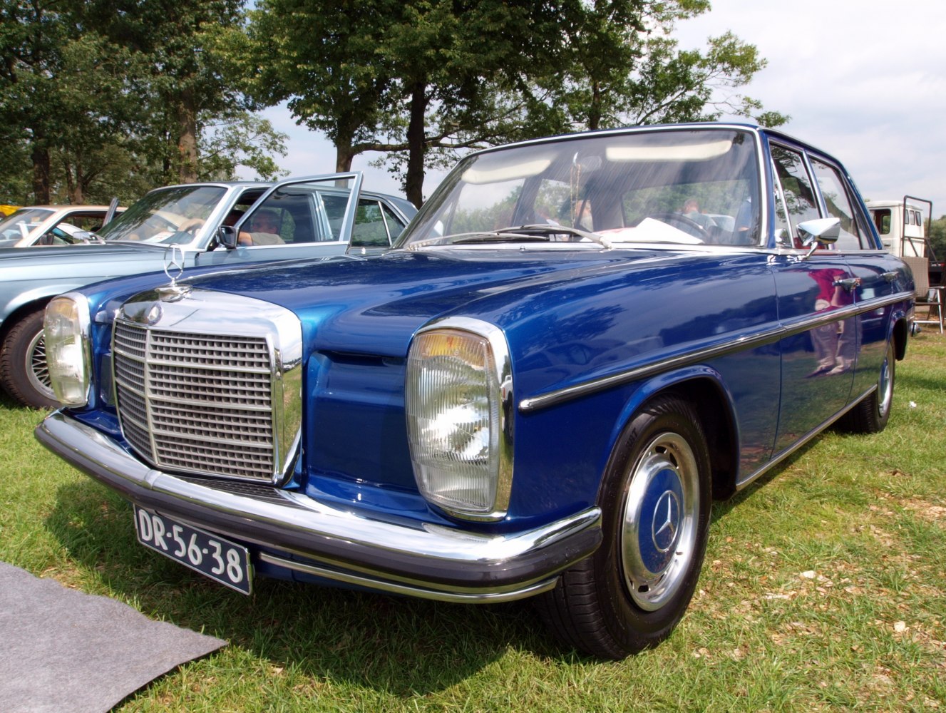 Vintage blue sedan with chrome grille and round headlights