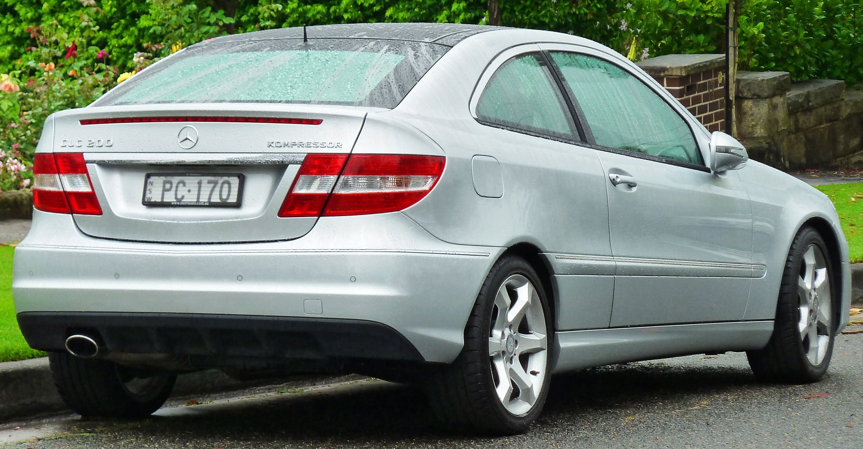 Rear view of silver coupe with taillights, alloy wheels, and Kompressor badge