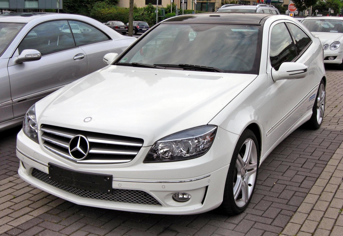 Front exterior view with headlights, grille, and alloy wheels of a sporty coupe.