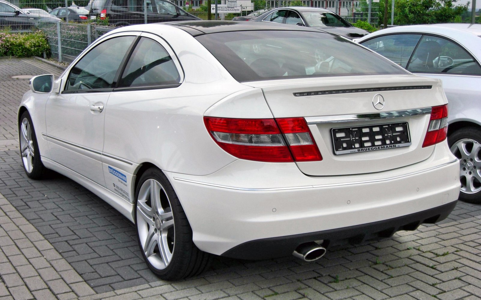 Rear view of luxury coupe with AMG wheels and integrated spoiler