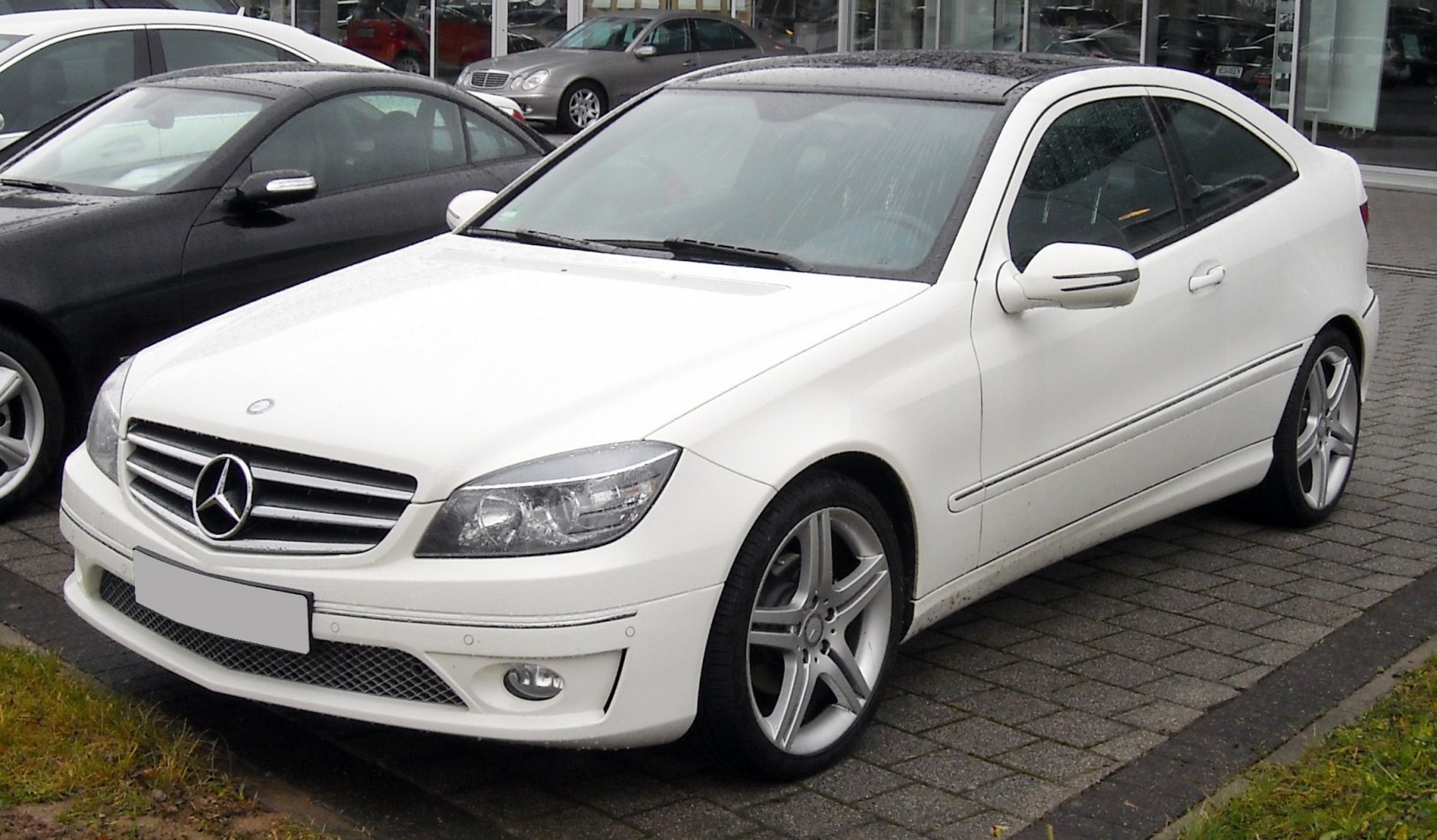 Front angled view of coupe with grille, headlights, and alloy wheels