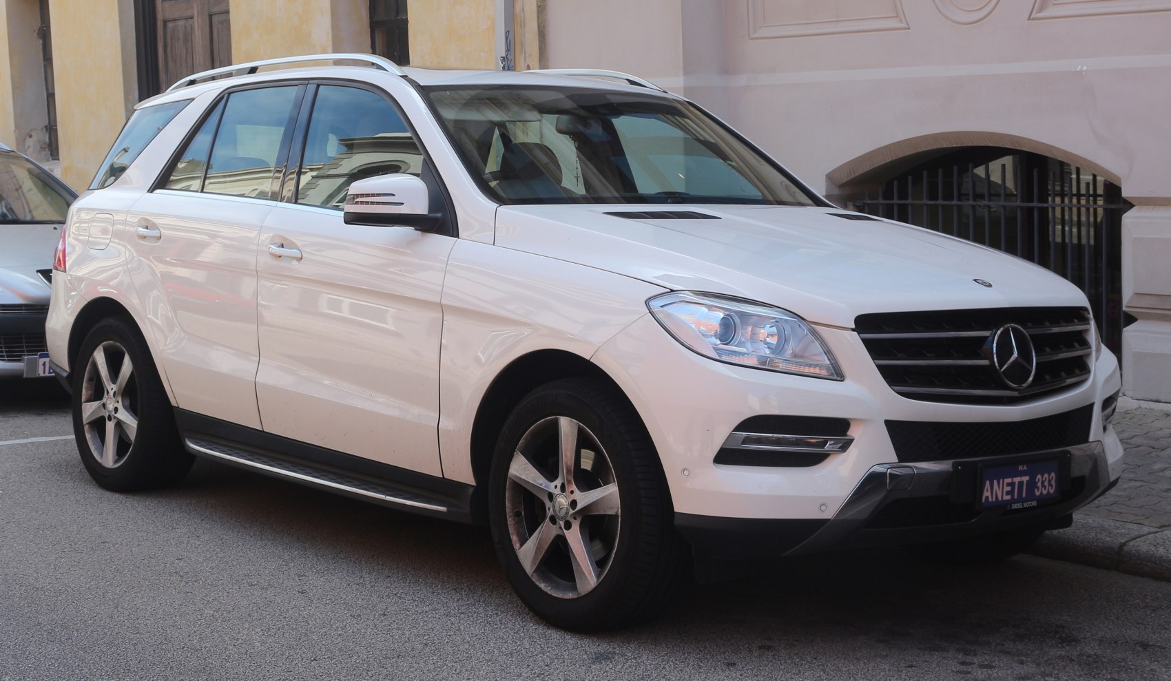 White SUV, front side view with alloy wheels, headlights, and roof rails.