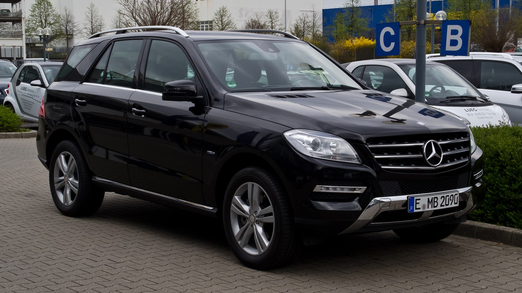 Black SUV front-side view with chrome grille and roof rails