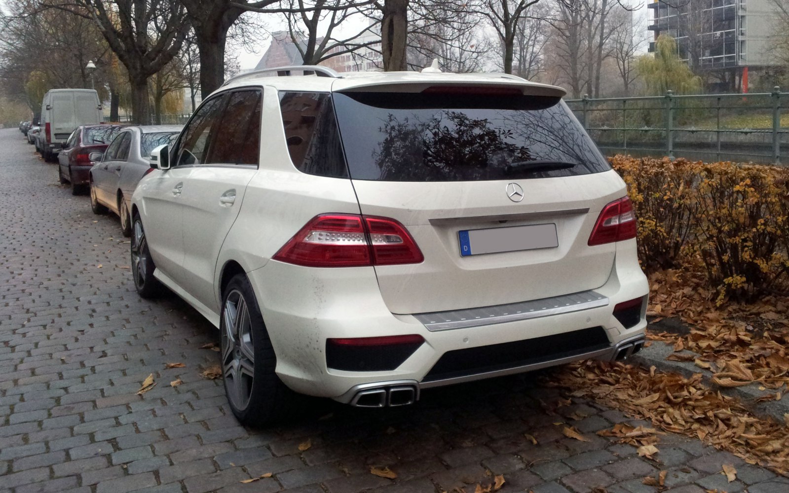 Rear view of white SUV with unique taillights and dual exhaust.
