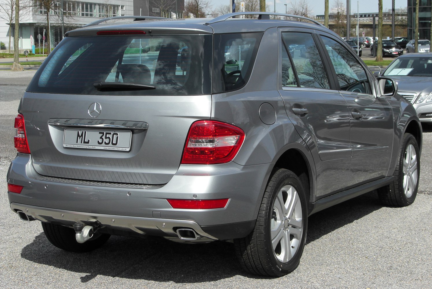 Rear of a silver SUV with dual exhaust and a tow hitch