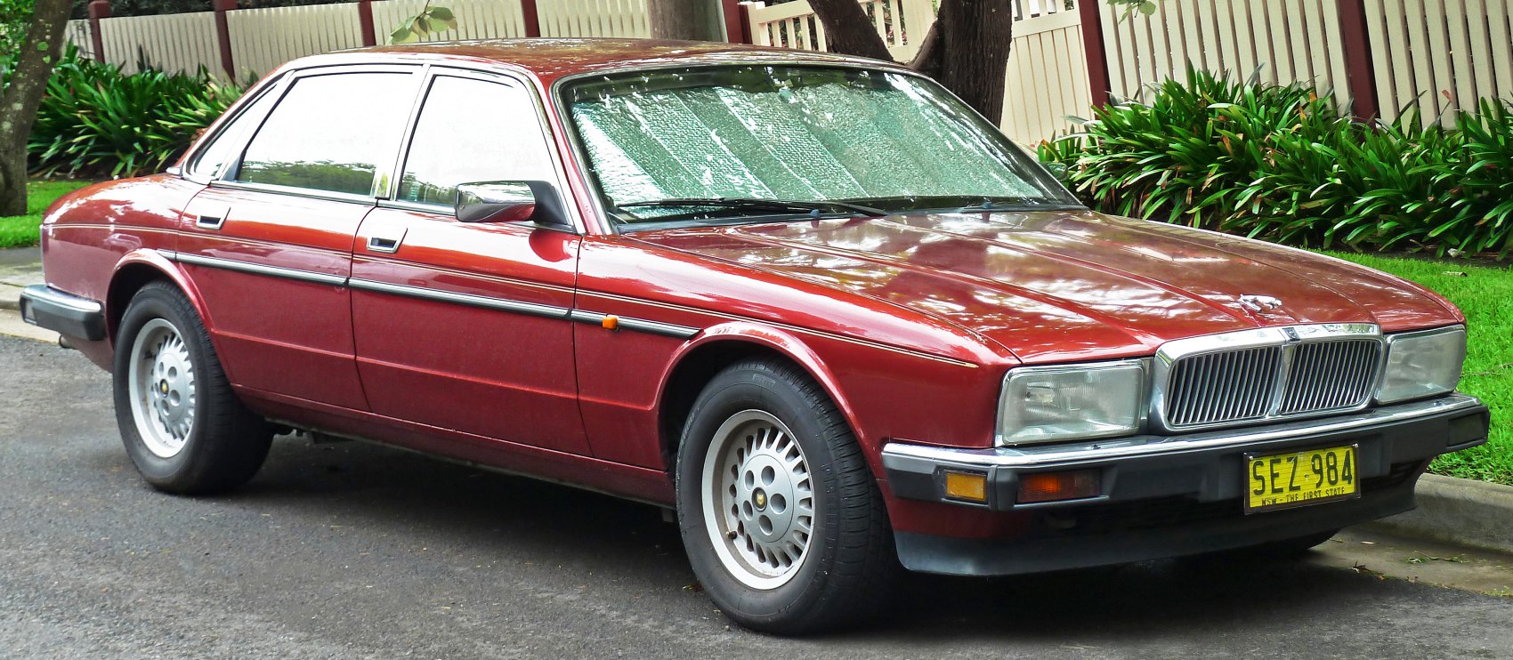Side and front view of classic sedan with rectangular headlights and alloy wheels