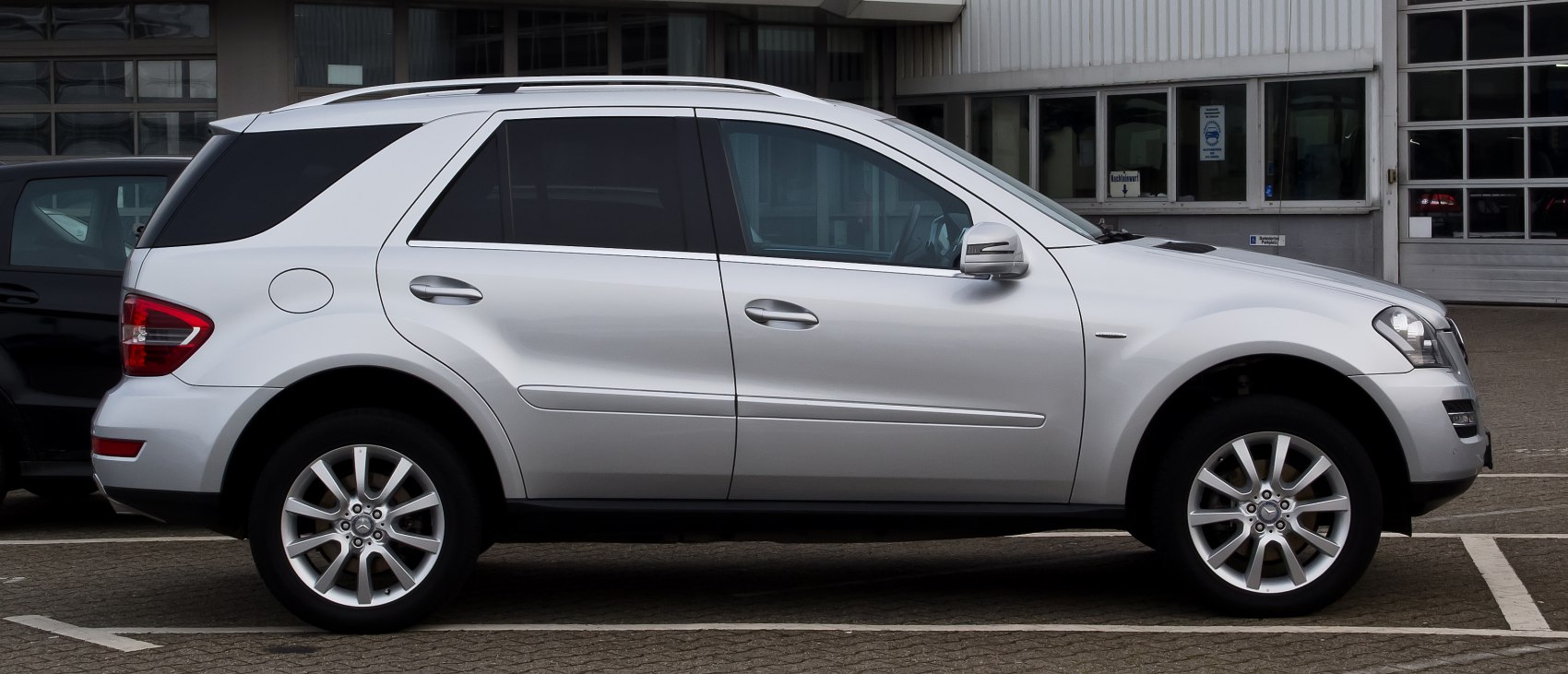 Side profile of silver SUV with alloy wheels and tinted windows