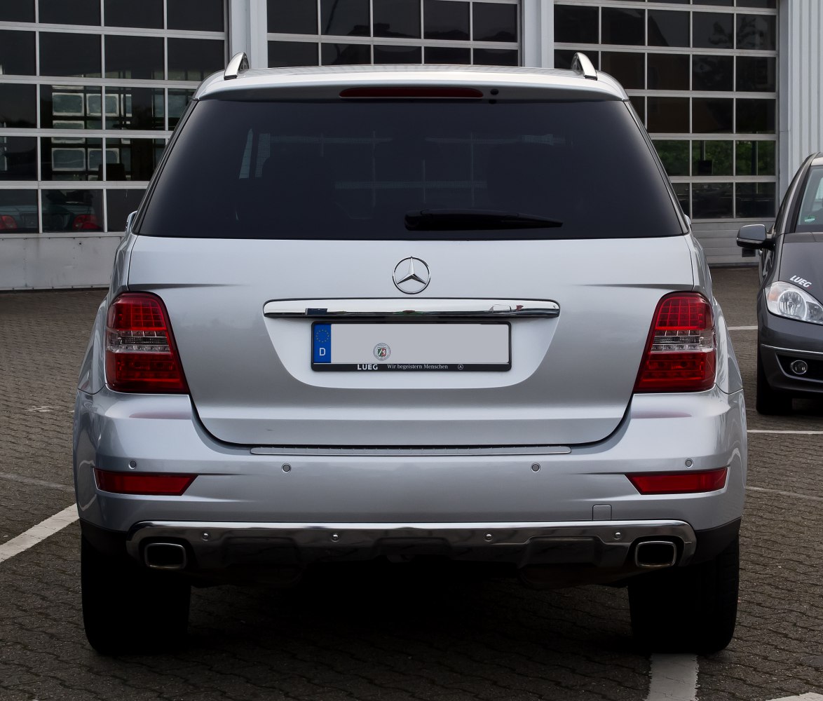 Silver SUV rear with vertical tail lights, dual exhaust, and rear sensors