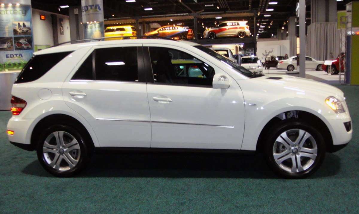 Side profile of white midsize luxury SUV with alloy wheels.