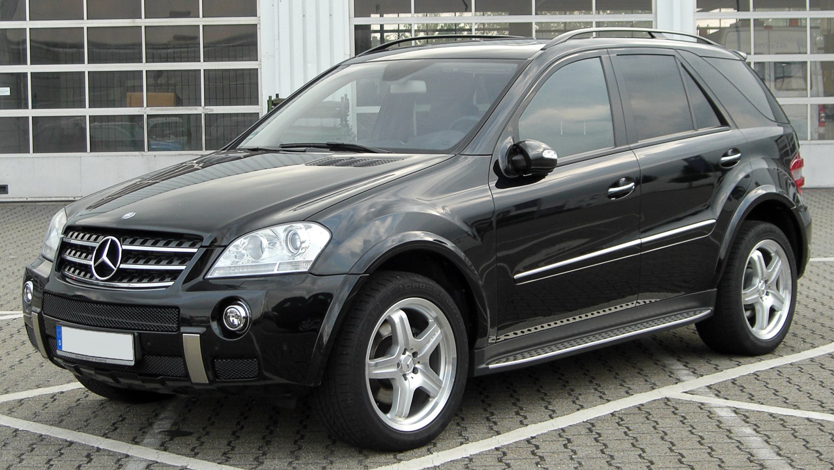 Black SUV front side with alloy wheels and roof rails