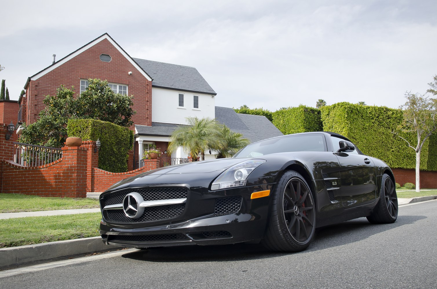 Front side view of a black luxury sports car with 63 badge and black alloy wheels