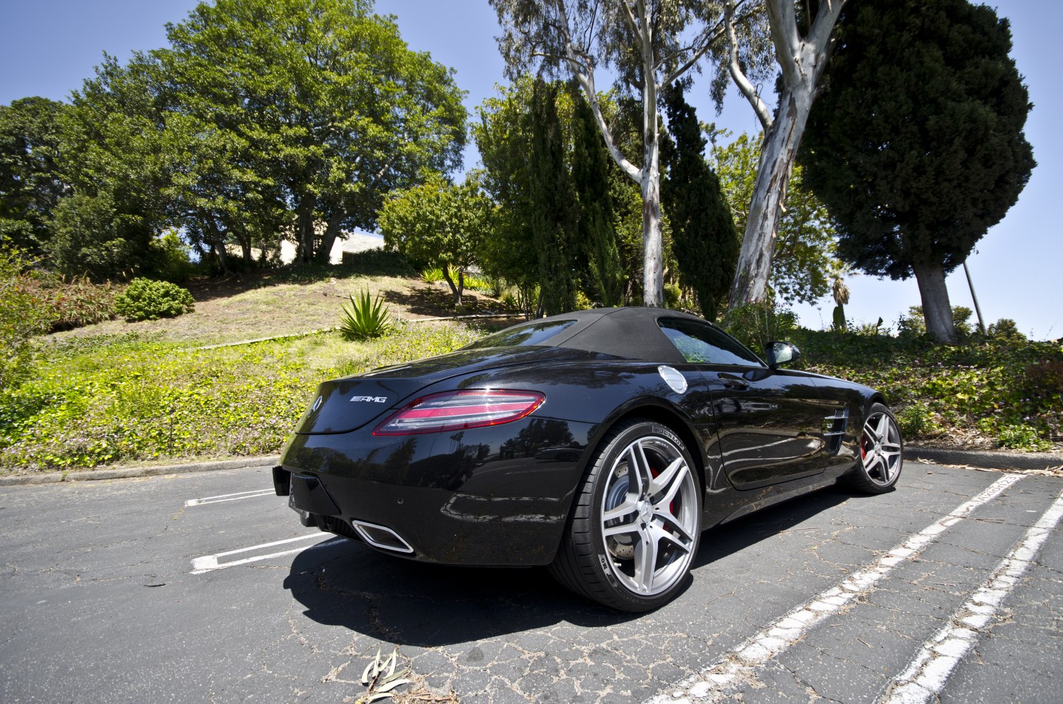 High-angle rear and side view of black convertible with alloy wheels
