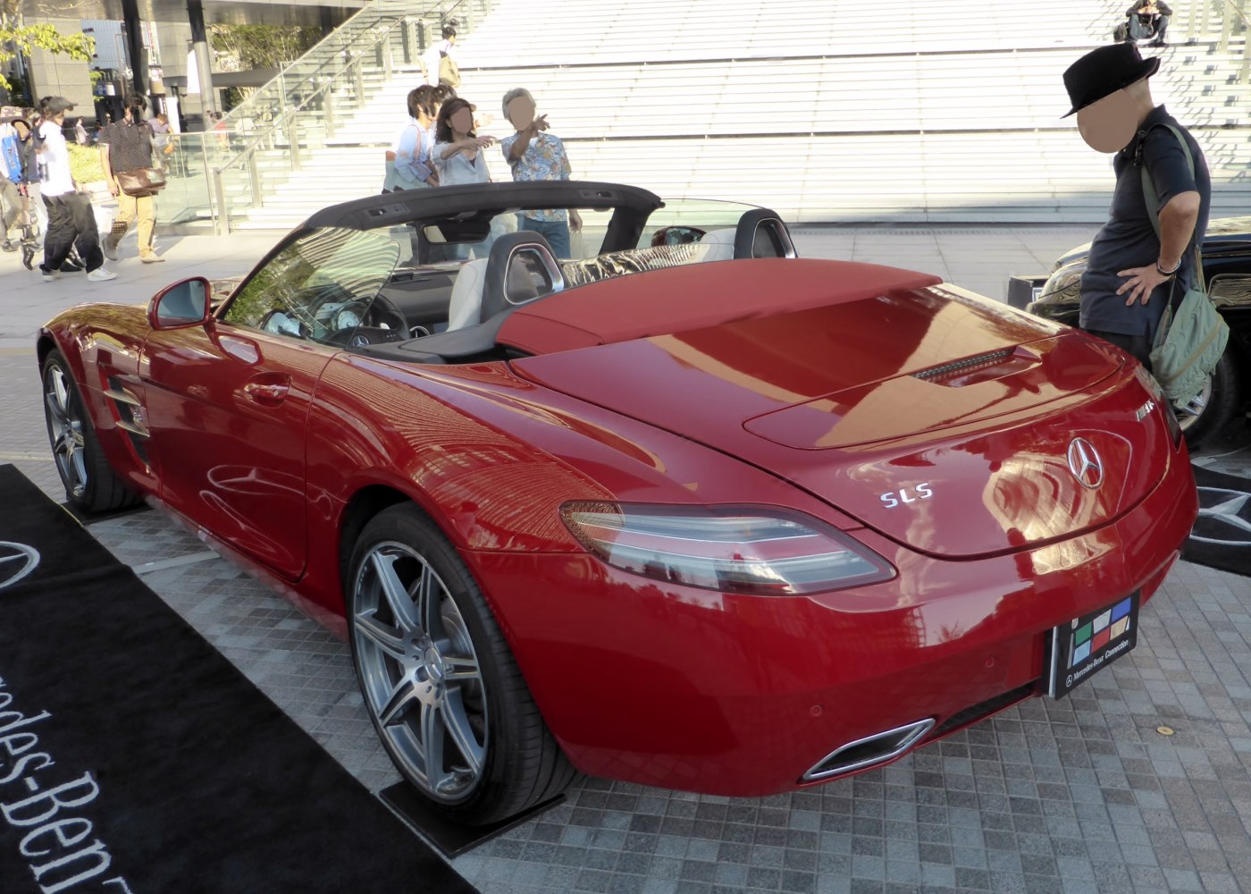 Red convertible with open roof, rear tail lights, dual exhausts, and sleek aerodynamic design