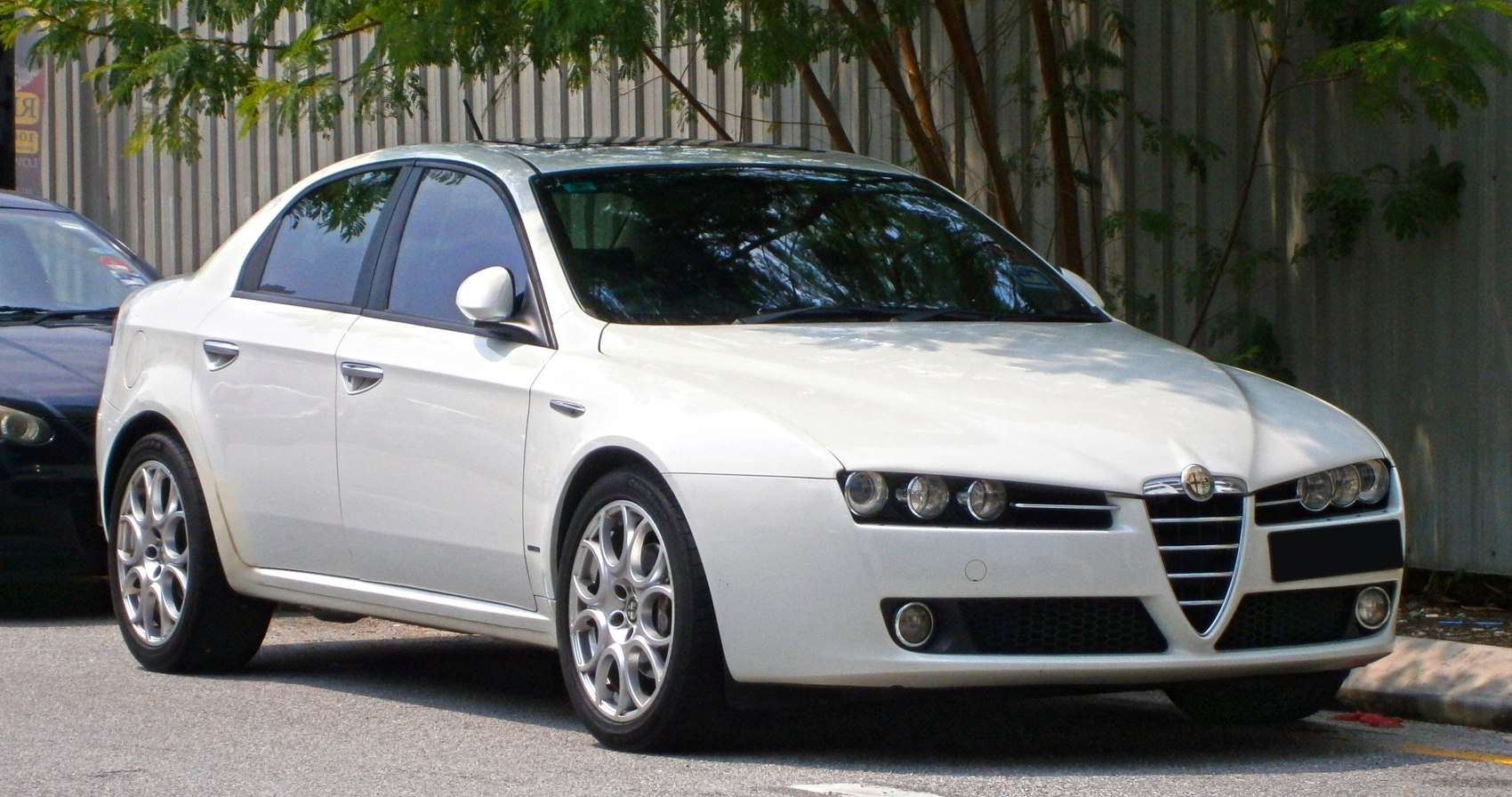 Salient triple headlights and multi-hole alloy wheels on mid-size sedan.