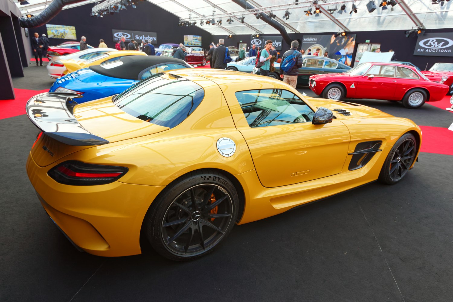 Yellow sports coupe with aerodynamic rear spoiler and black wheels.