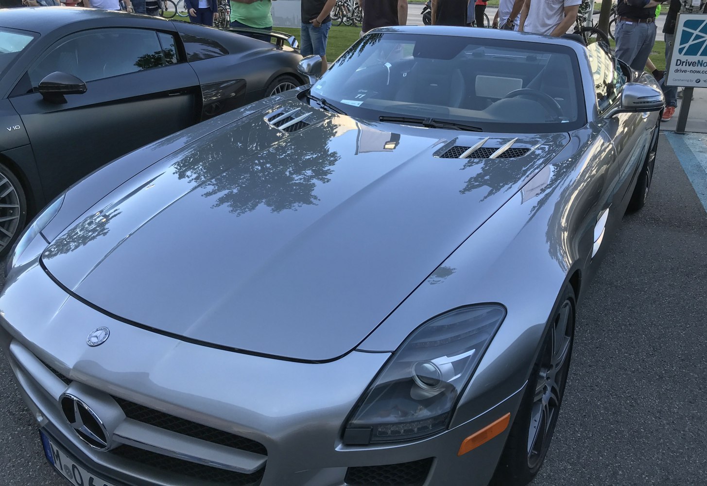 Silver sports car hood with dual air vents and distinctive sharp headlights