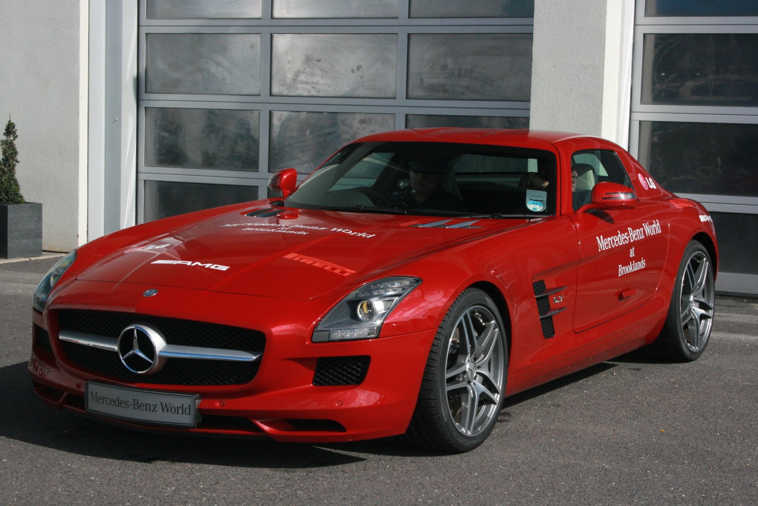 Red luxury coupe with front grille, AMG badge, and sporty alloy wheels