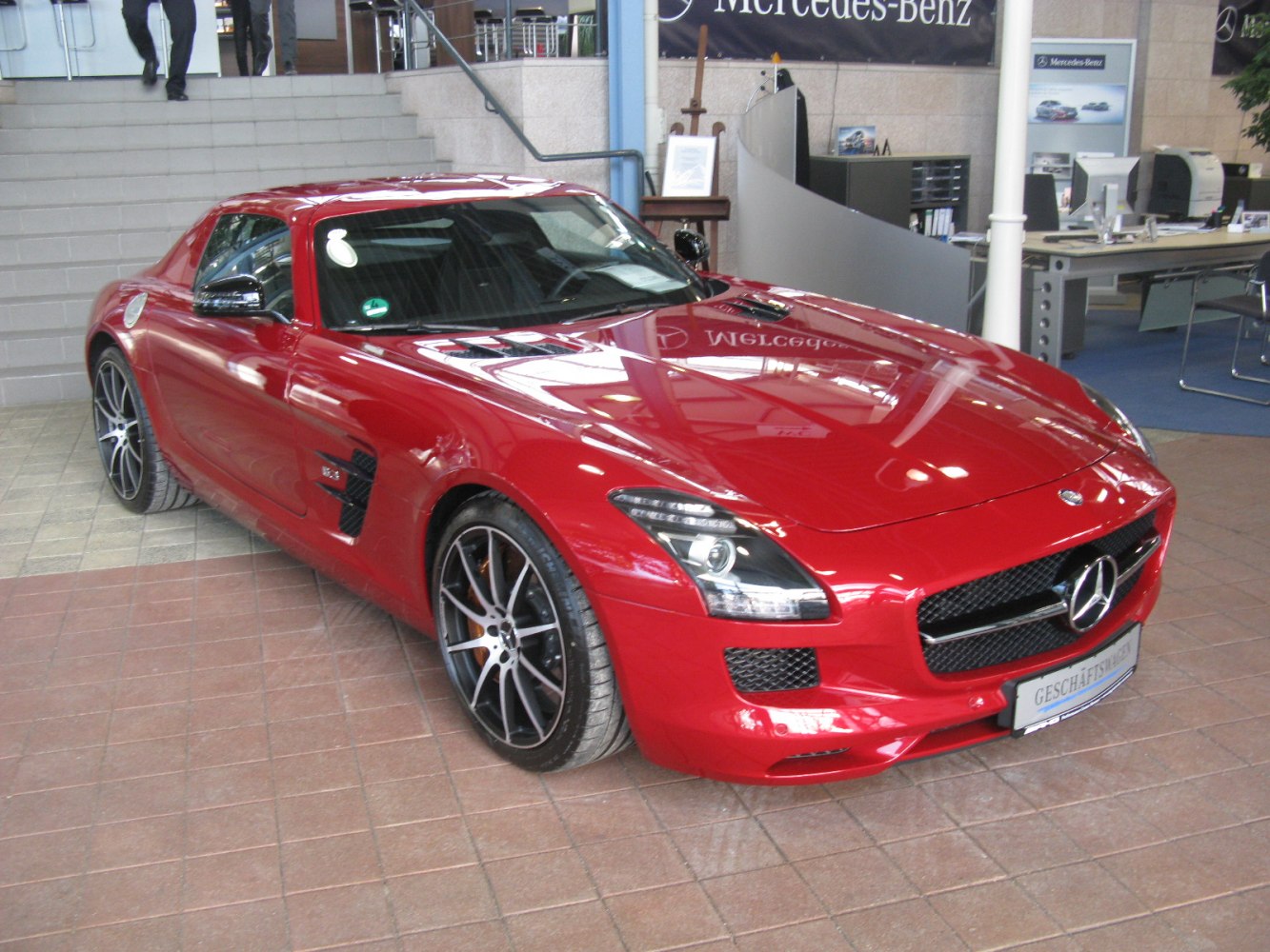 Red sports coupe with prominent front grille and aerodynamic vents