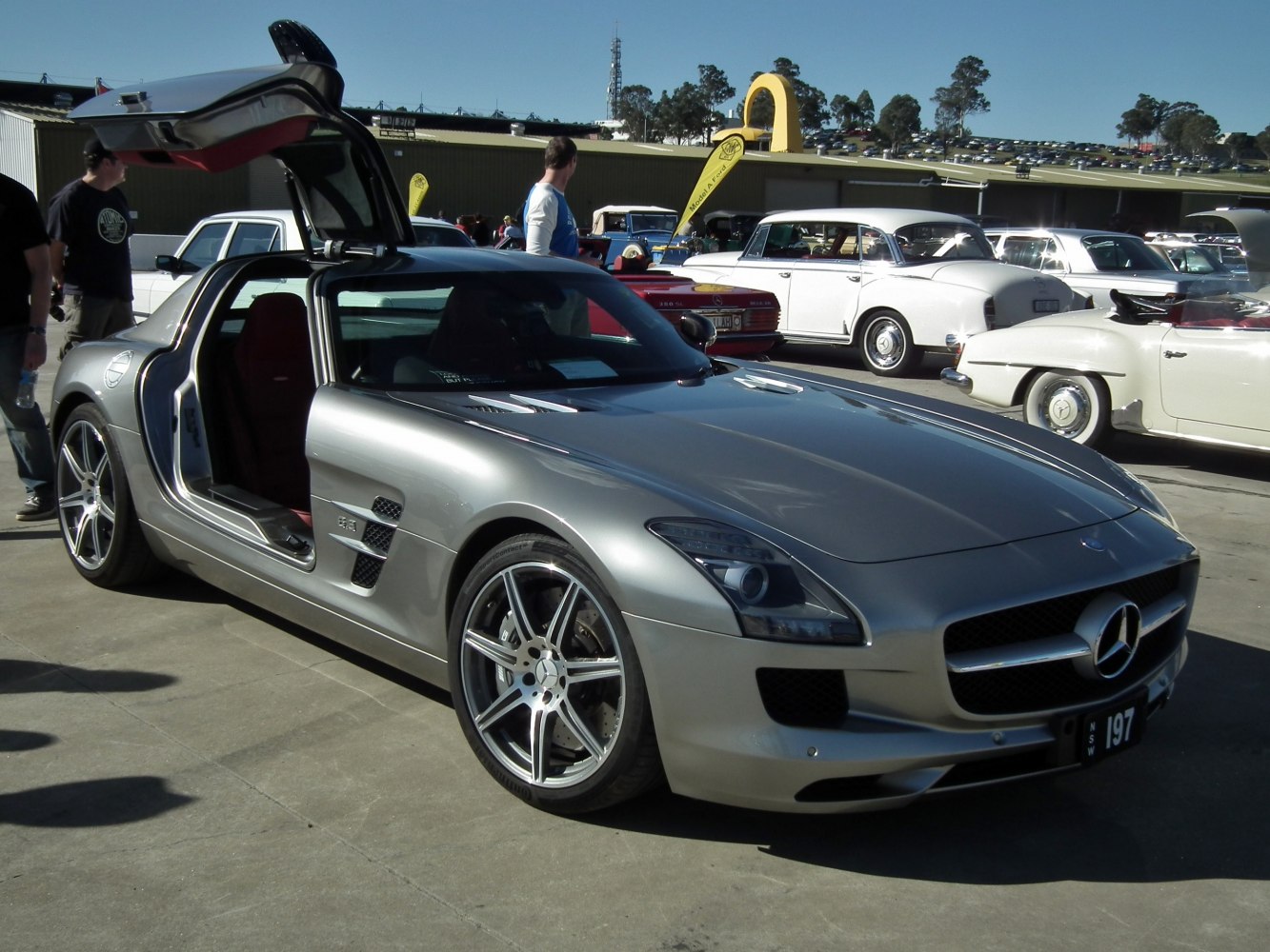 Silver sports coupe with distinctive gullwing doors open