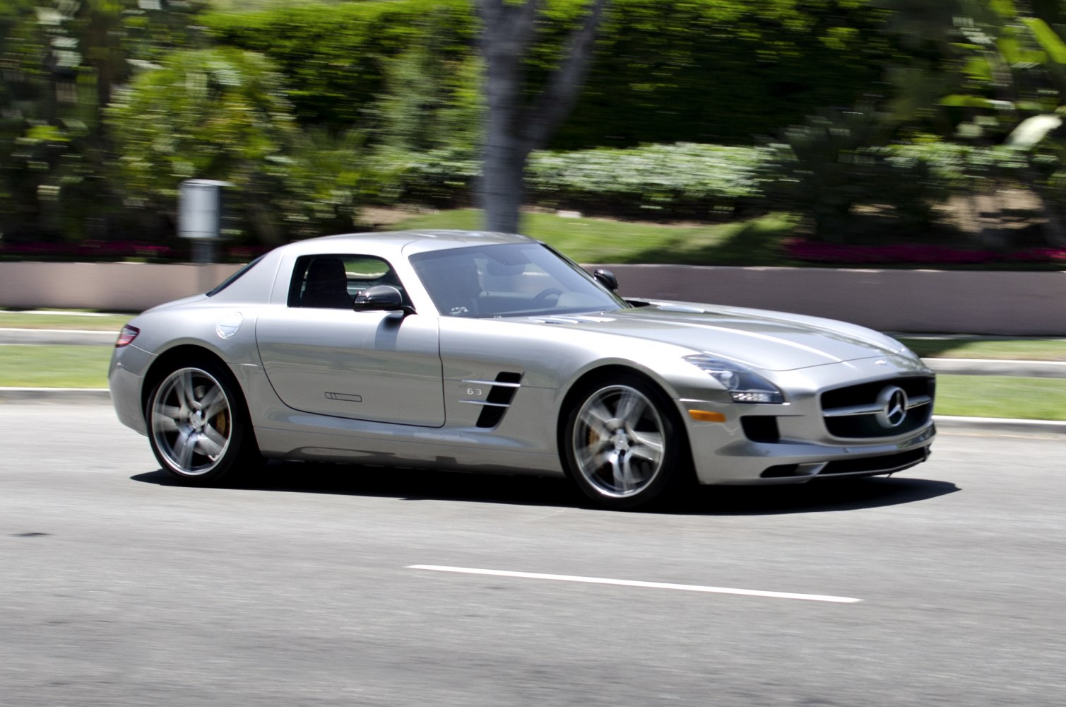 Silver sports coupe with gullwing doors and sleek aerodynamic design