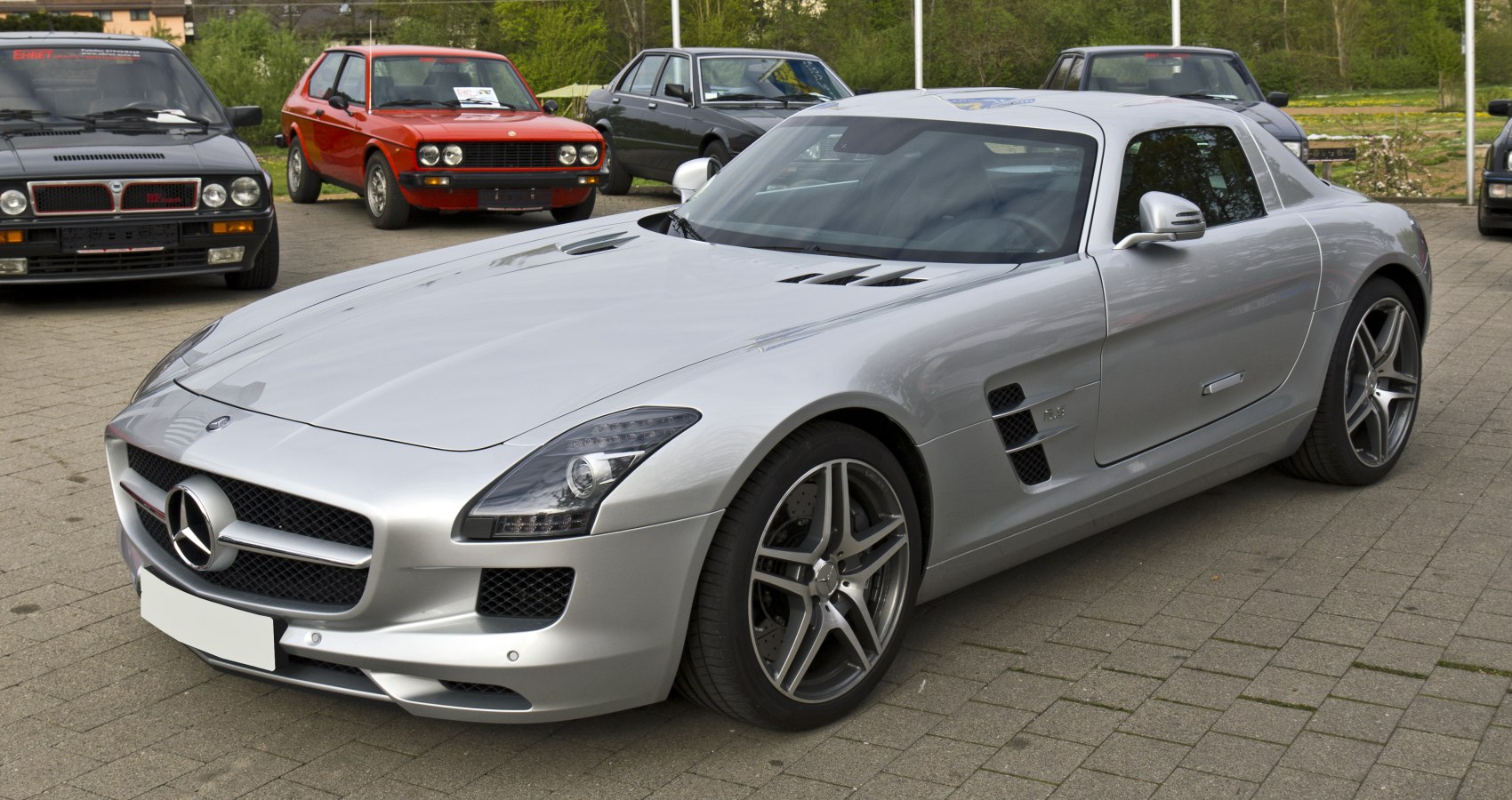 Silver sports coupe with aerodynamic vents and distinctive front fascia.