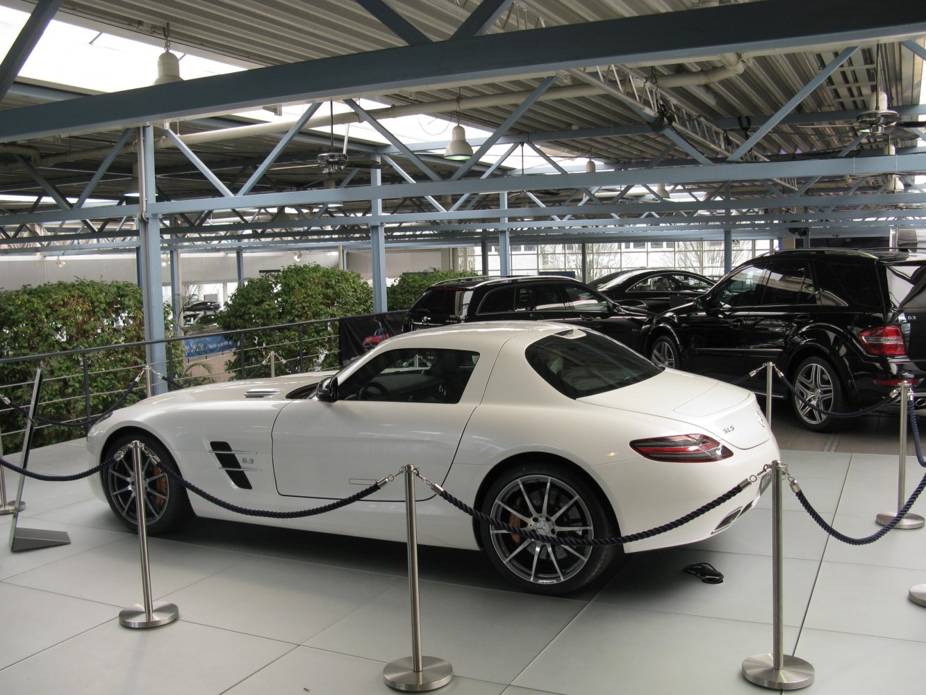 Rear side view of white luxury sports coupe inside showroom