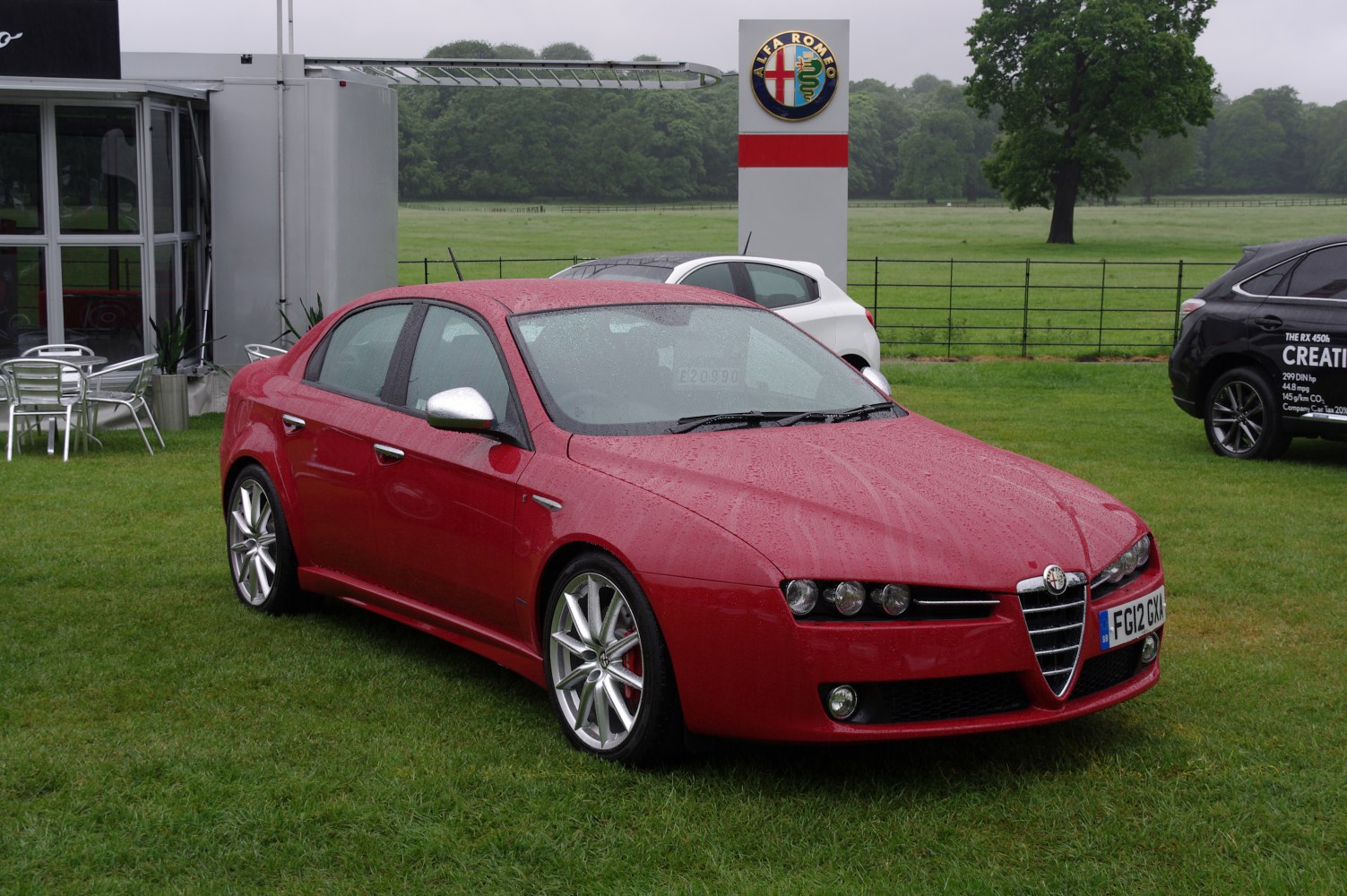 Red sedan with signature triple headlights and sporty alloy wheels