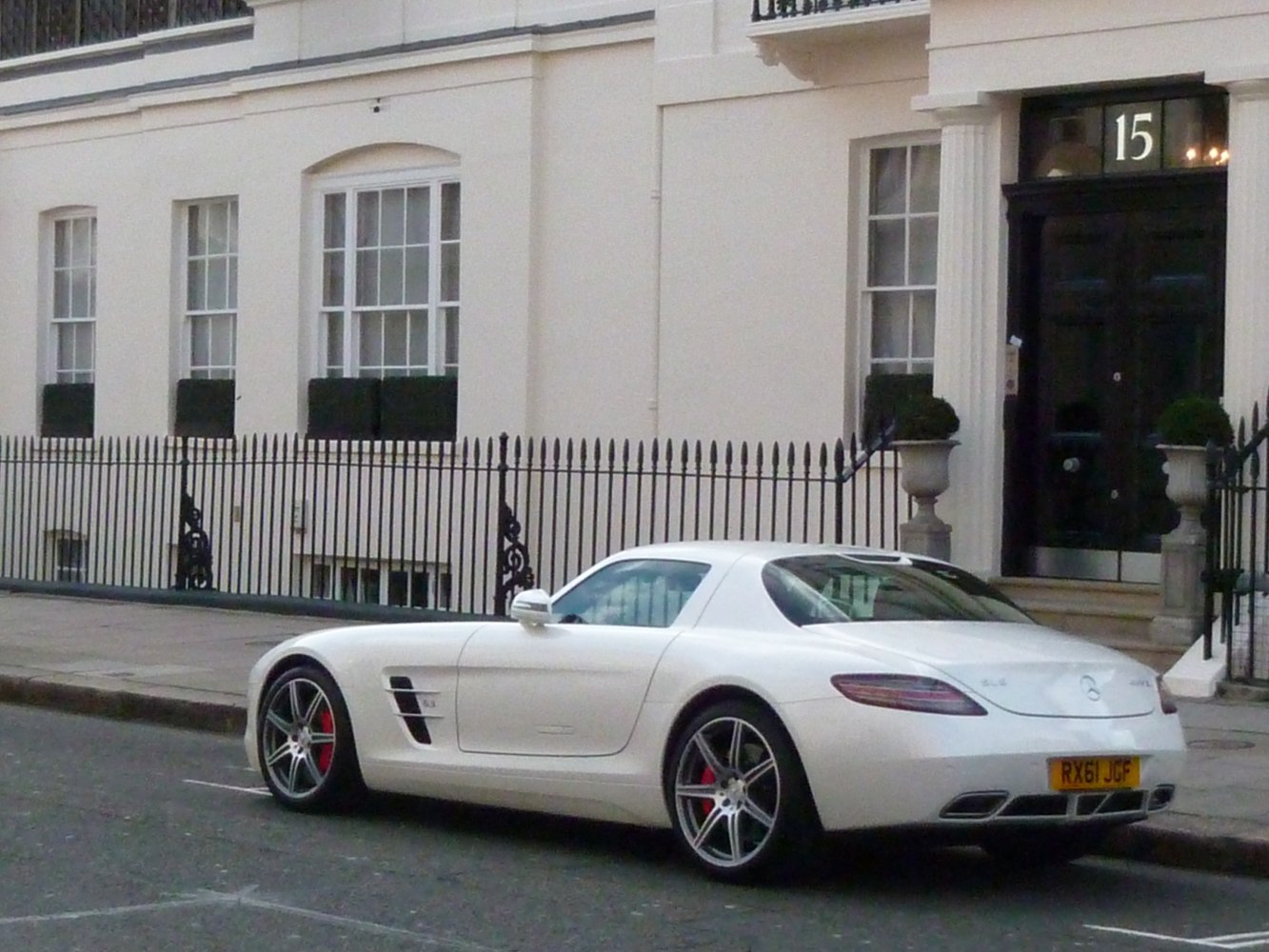 White sporty coupe with rear design, side vents, and alloy wheels