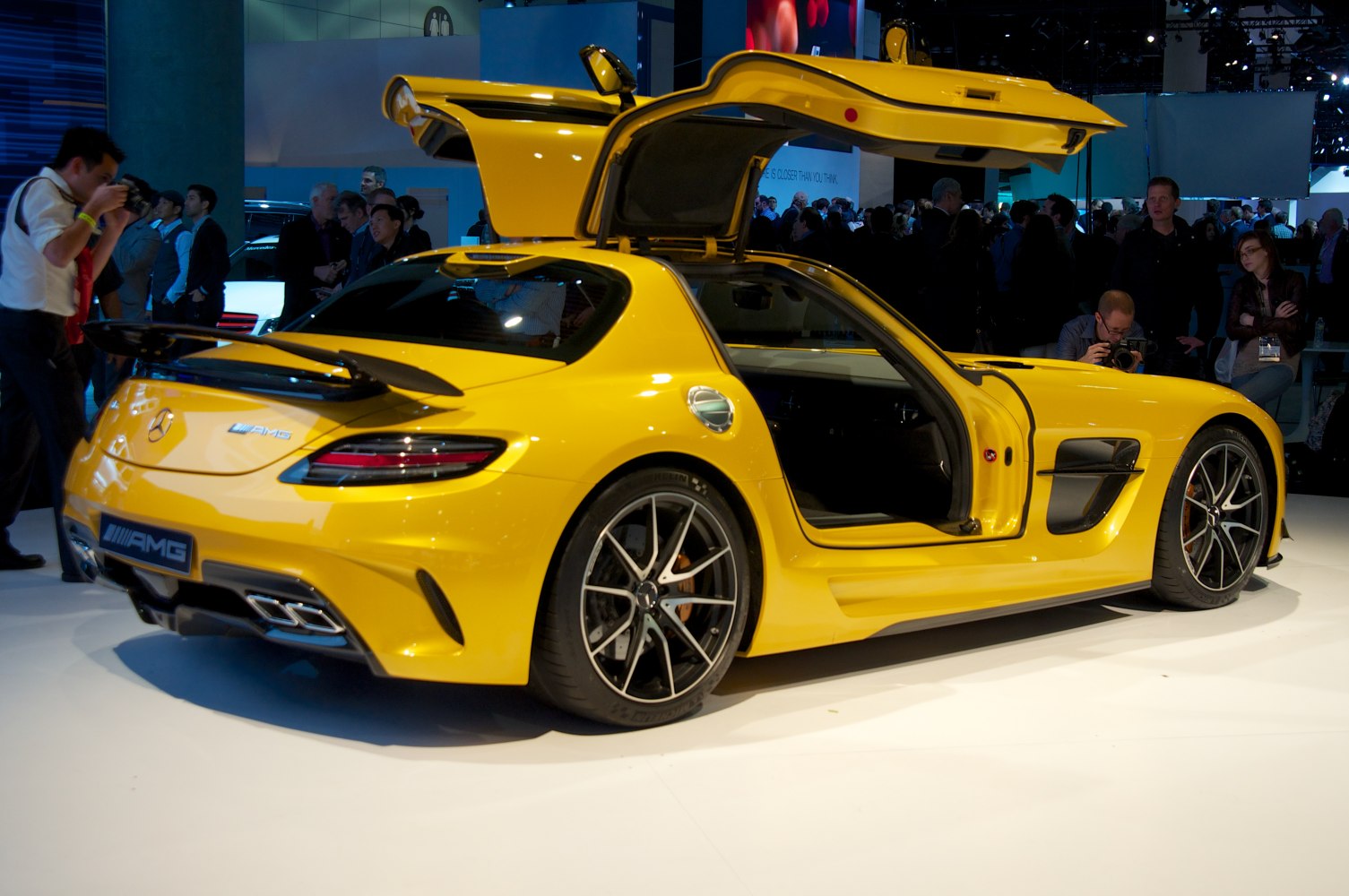 Yellow coupe with gullwing doors open and rear spoiler