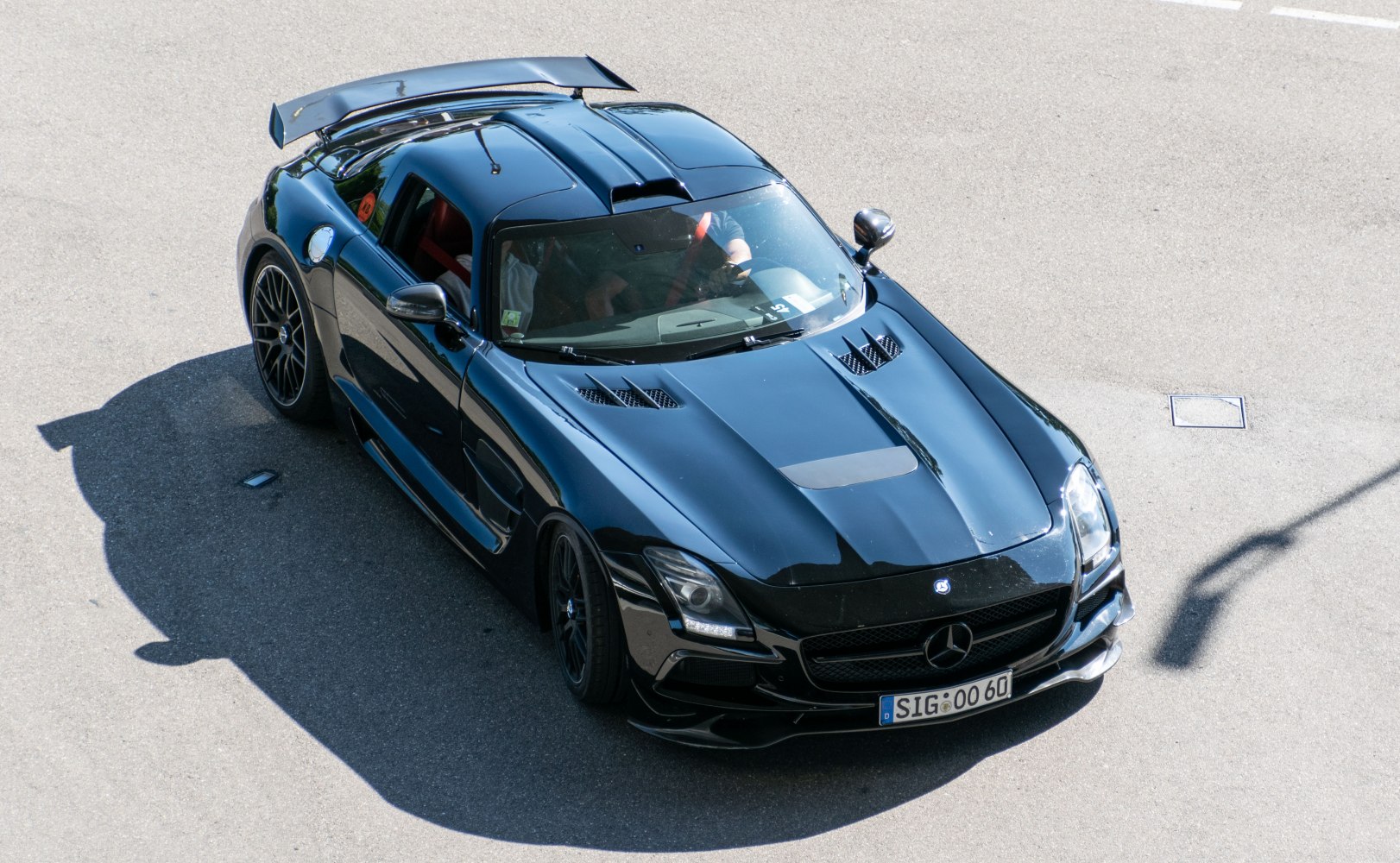 Front angle of black sports coupe with hood vents and rear spoiler