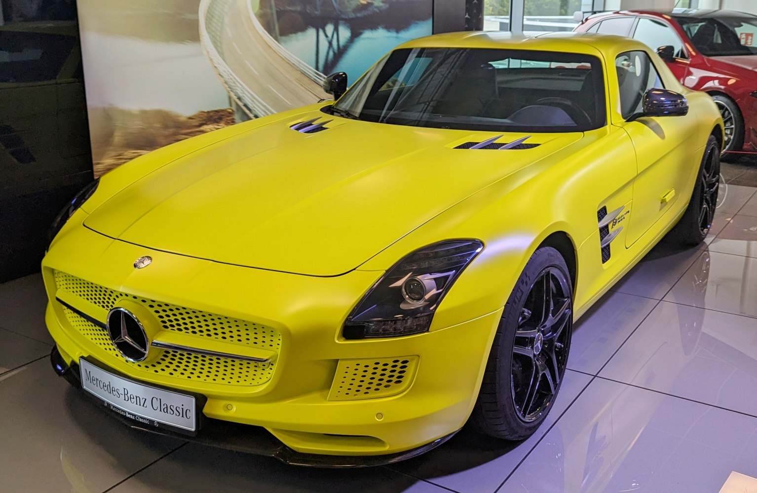 Yellow sports coupe front view with black wheels and aerodynamic vents
