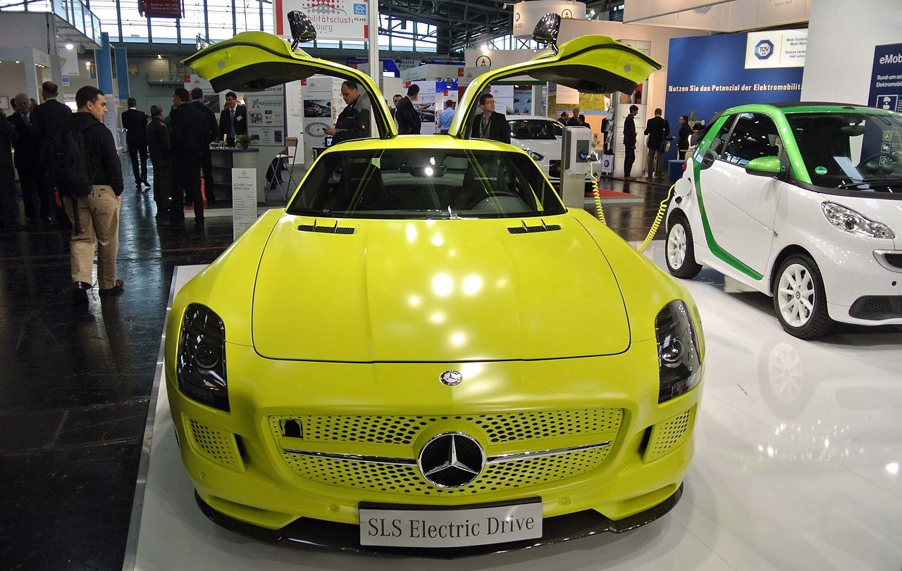 Front view of yellow electric supercar with gullwing doors open