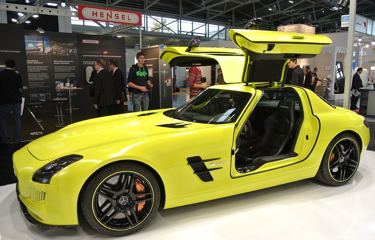 Yellow sports coupe with gullwing doors and black wheels